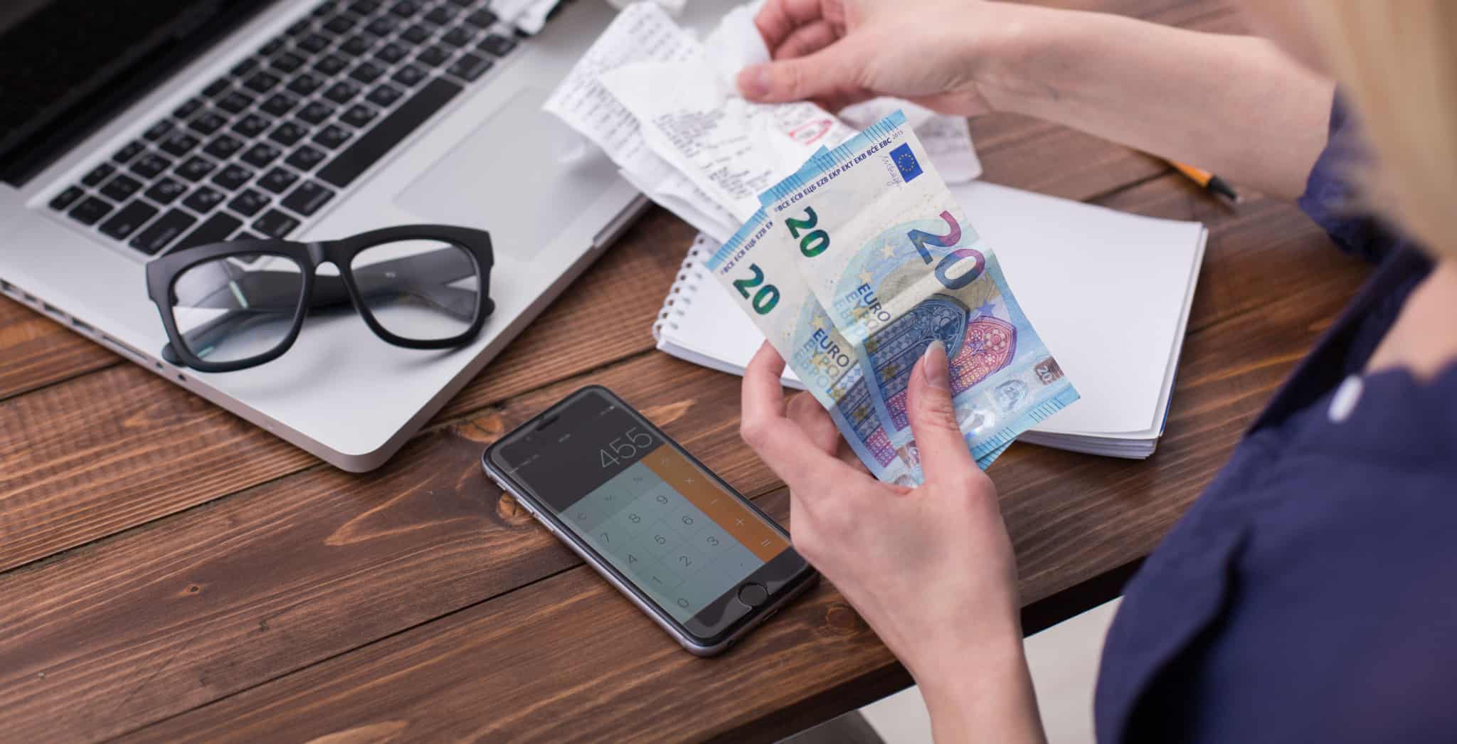 mulher com algumas notas de 20 euros nas mãos faz as contas às despesas