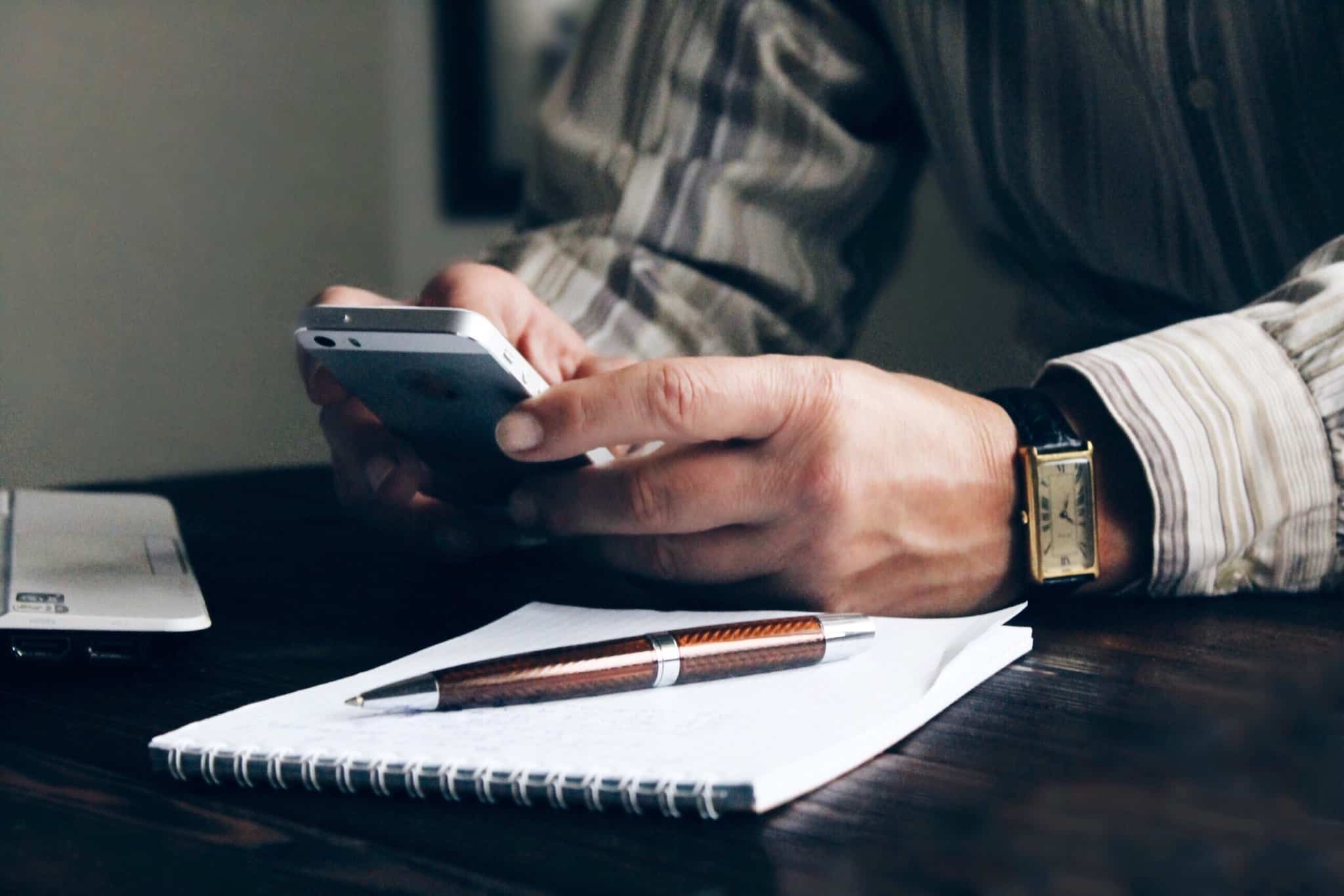 relógio de pulso e homem no telemóvel