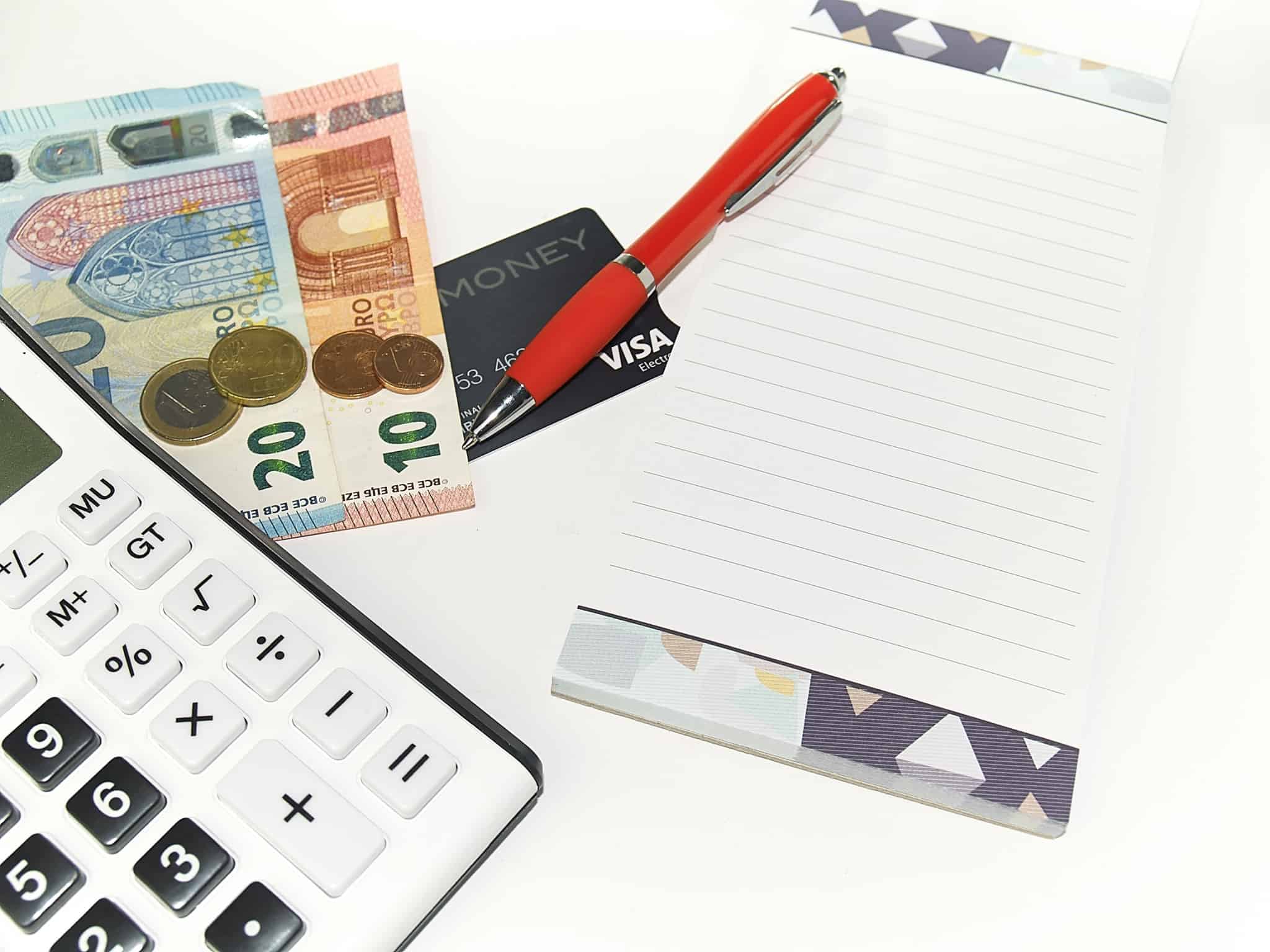 bloco de notas com calculadoras e caneta e cartao visa e notas de euro