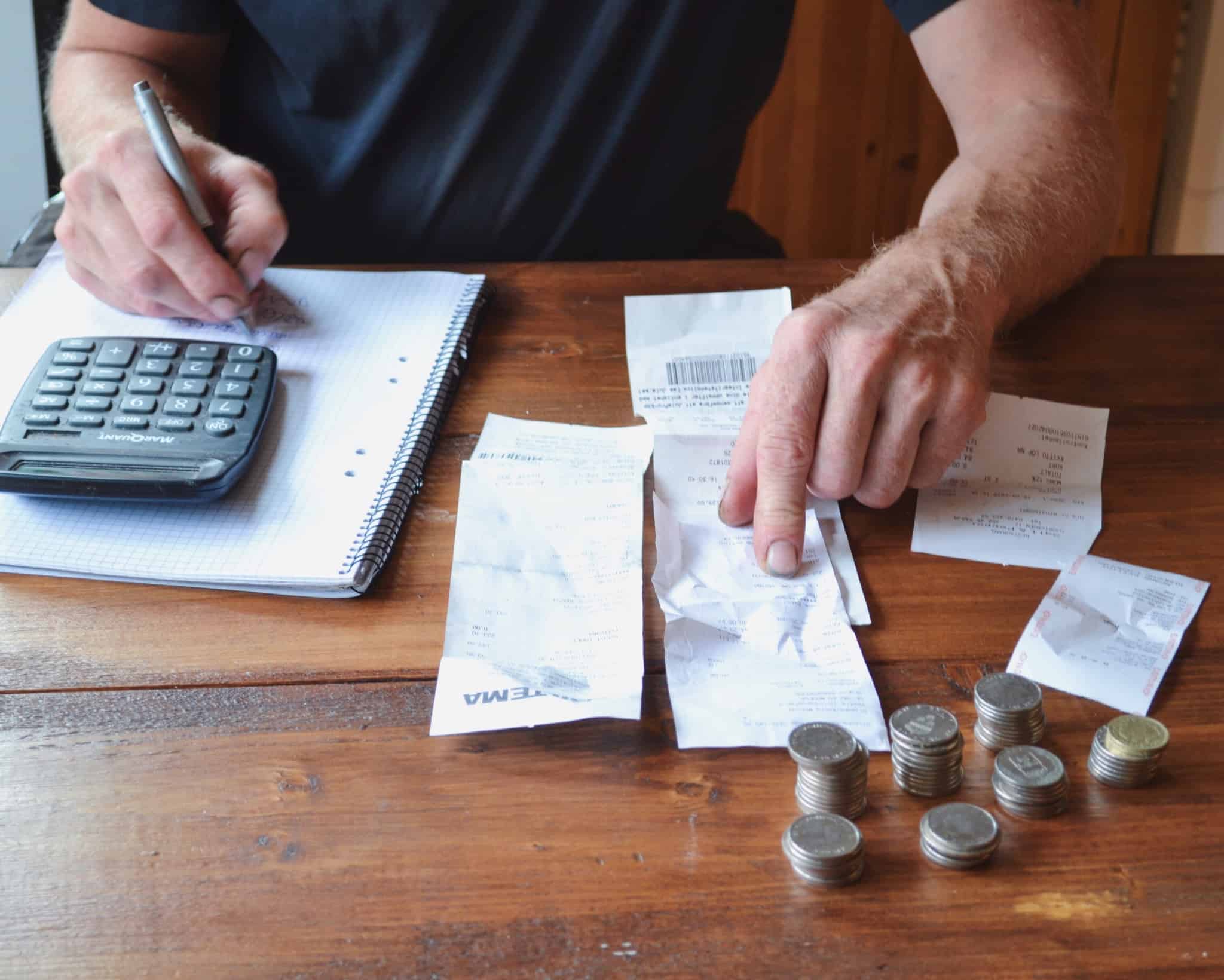 pessoa verifica faturas bloco de notas e calculadora