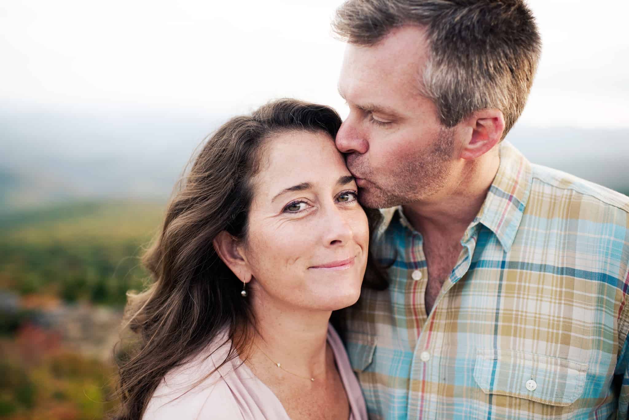casal com o homem a beijar a testa da mulher