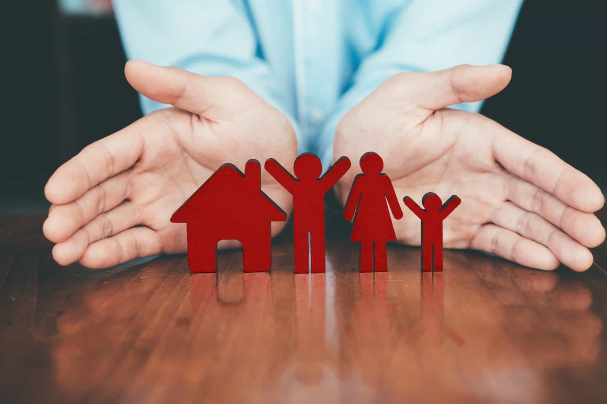 Mãos a proteger uma casa e uma família