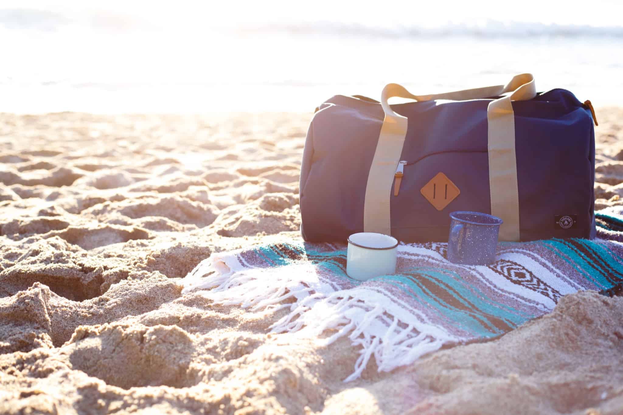 saco de viagem na areia da praia