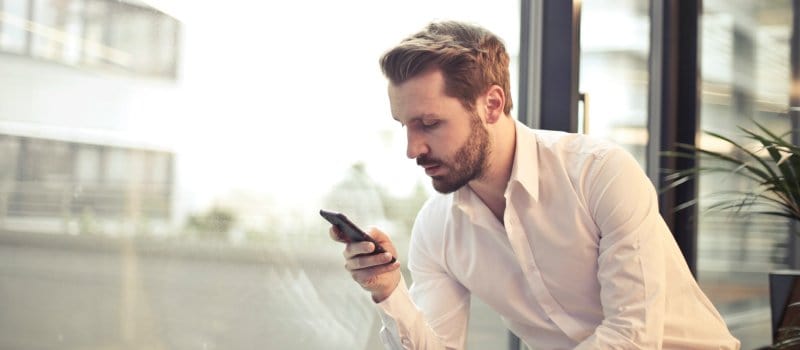 homem a olhar para o telemóvel