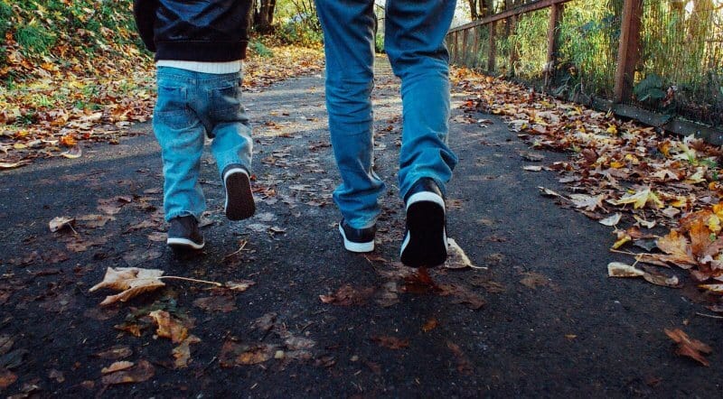 pai e filho a andar numa rua no outuno