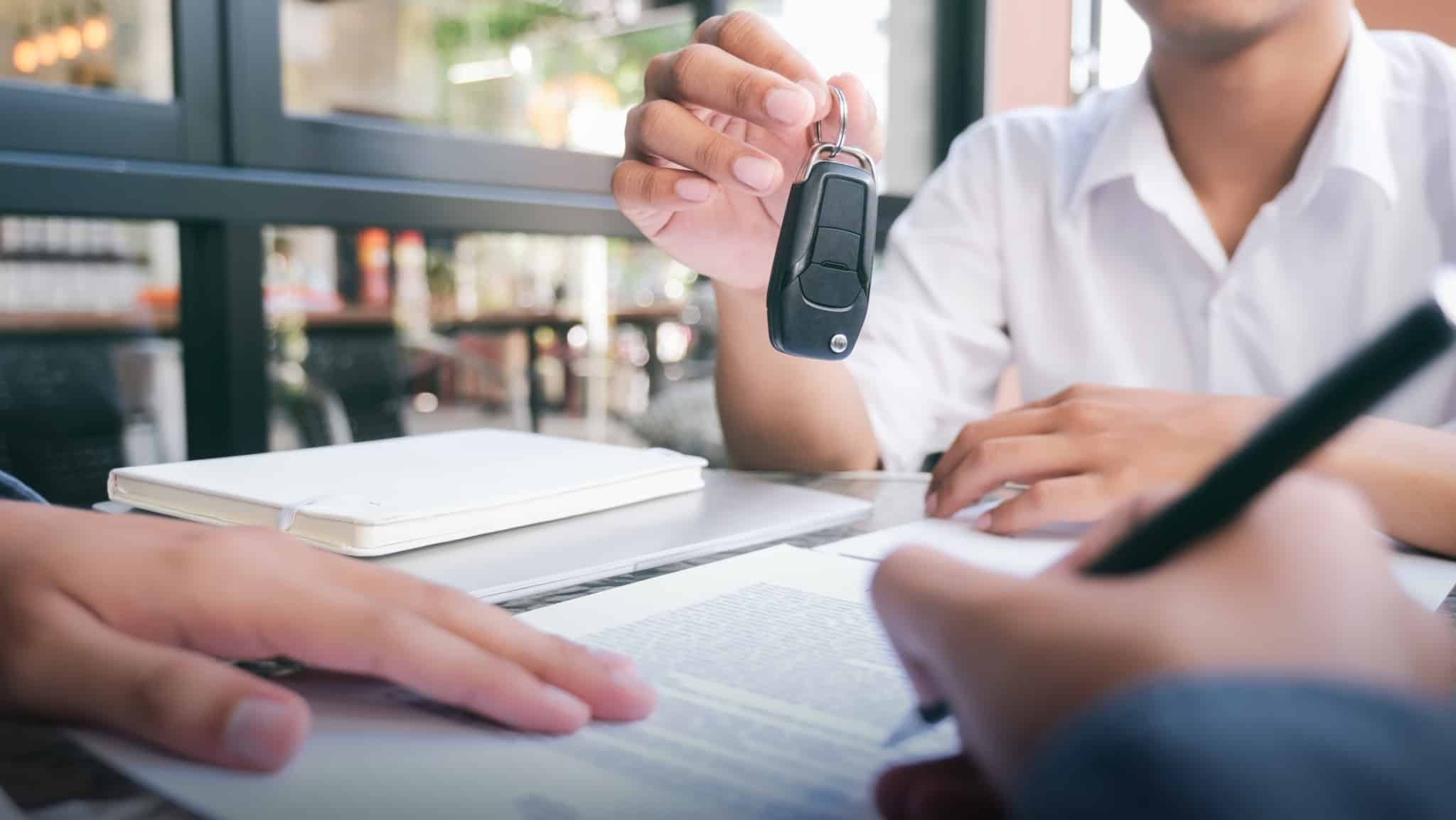 pessoa a comprar carro a segurar a chave do carro