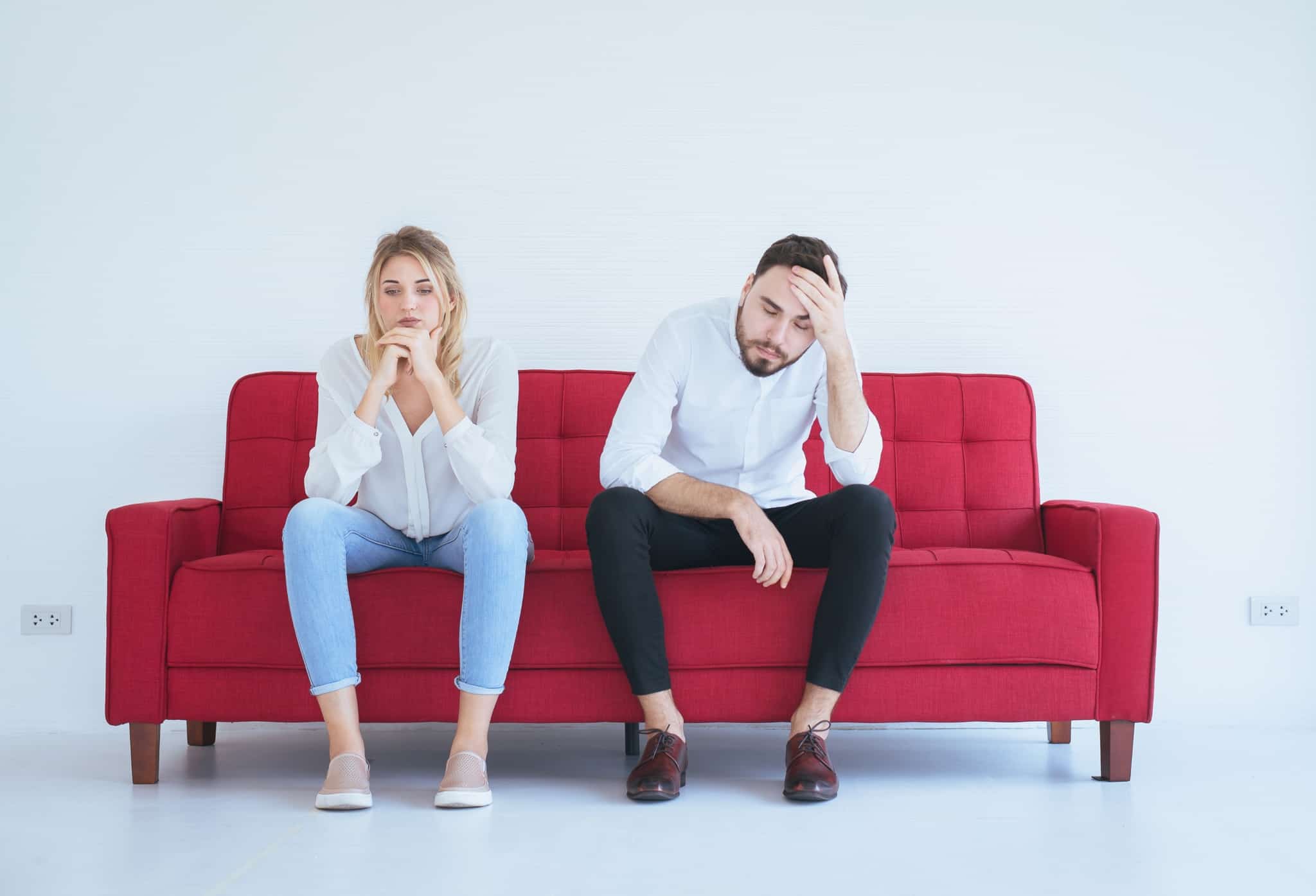 casal sentado num sofa vermelho