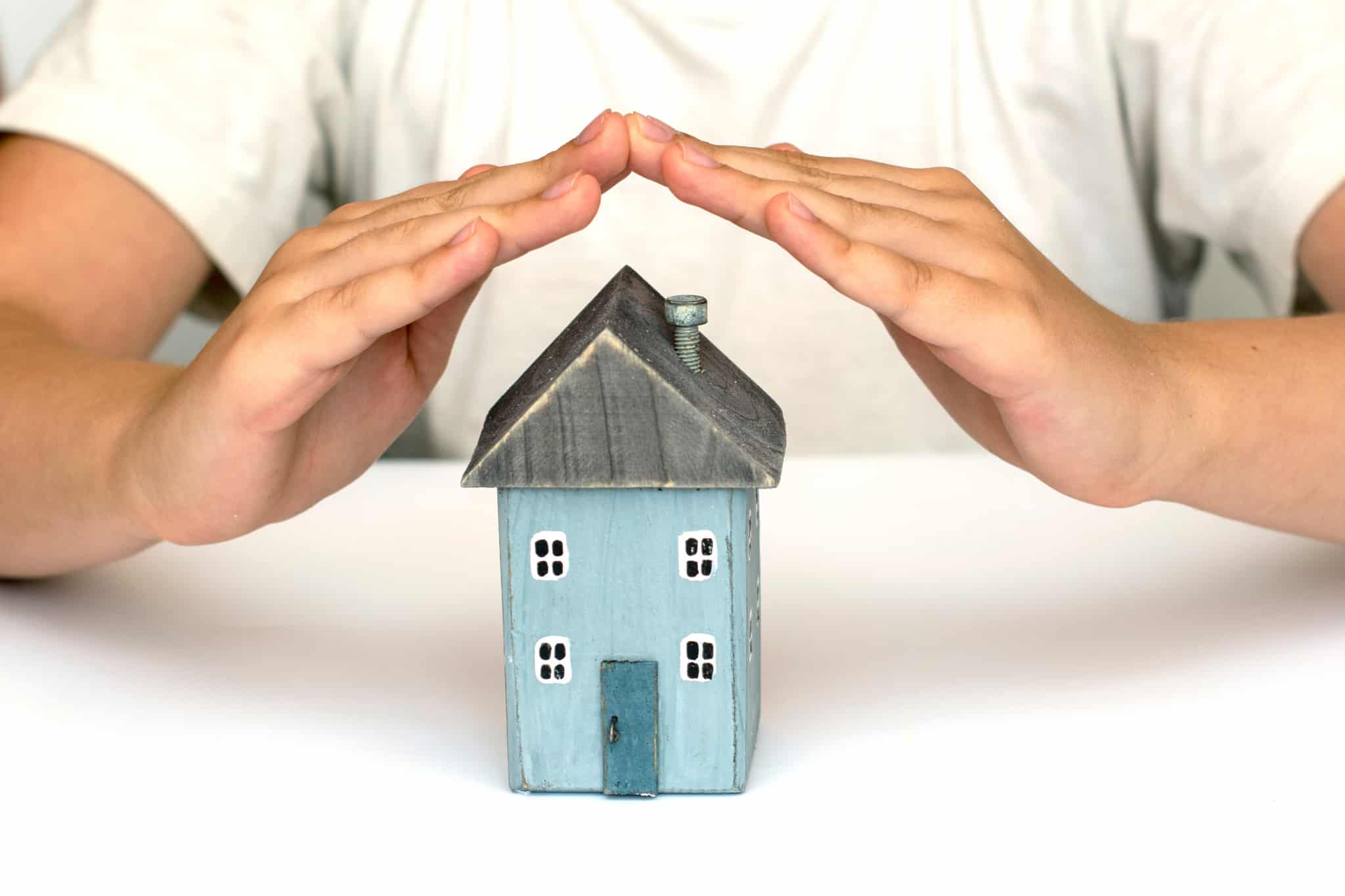 Homem-a-proteger-a-casa-com-as-mãos_-seguro-de-crédito-Habitação