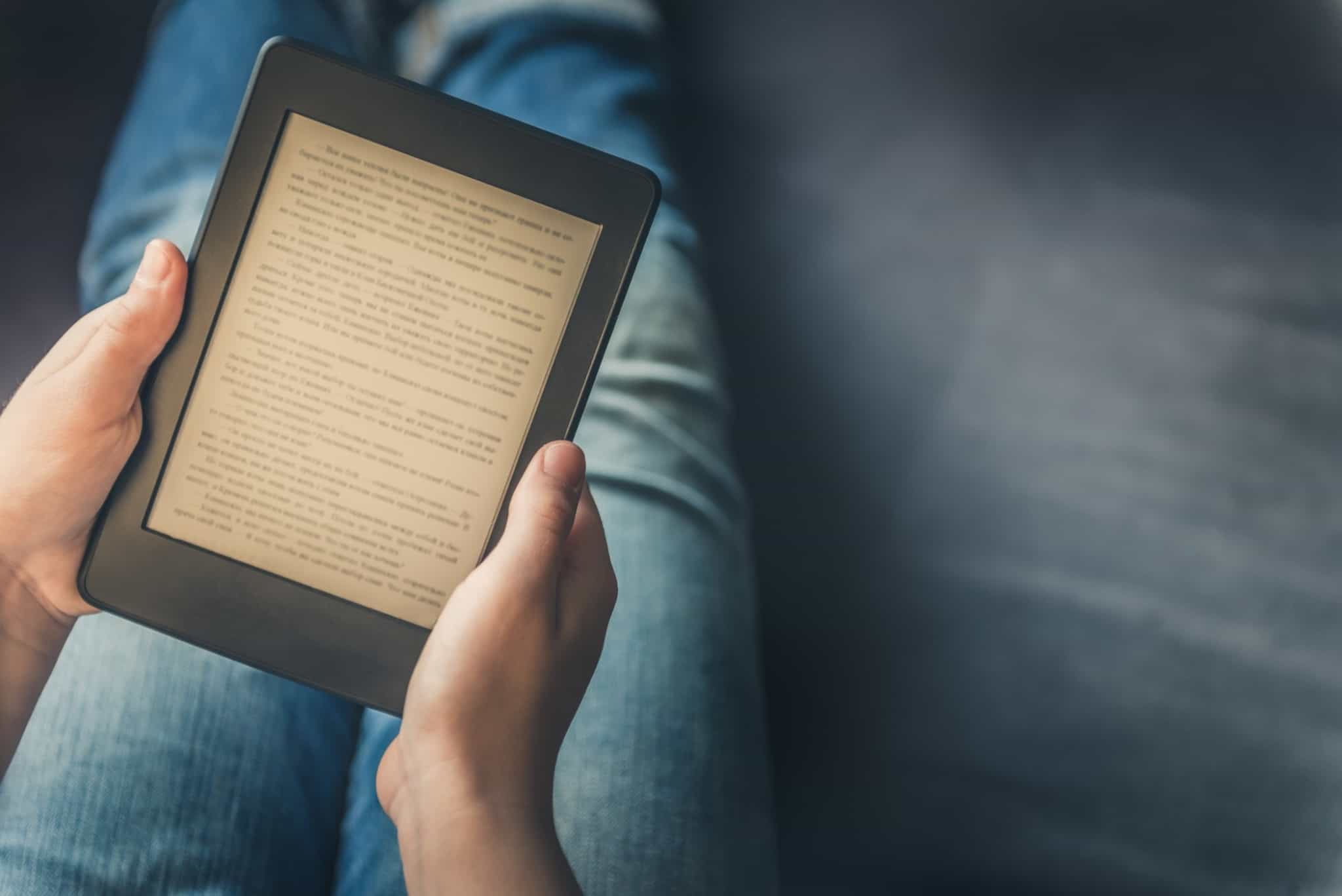 pessoa a ler ebook no sofá