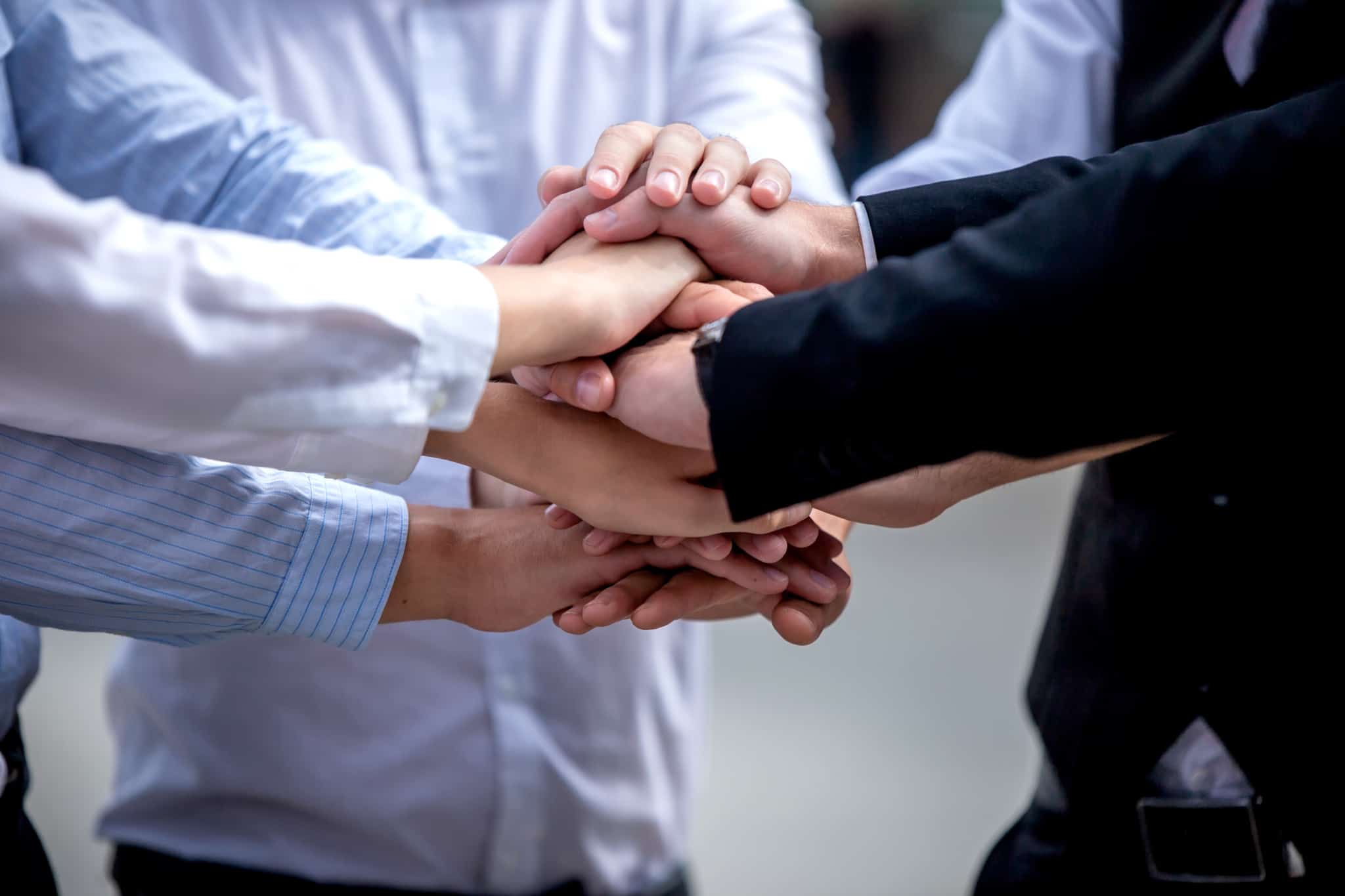 Homens-de-negocios-com-as-maos-em-sinal-da-uniao