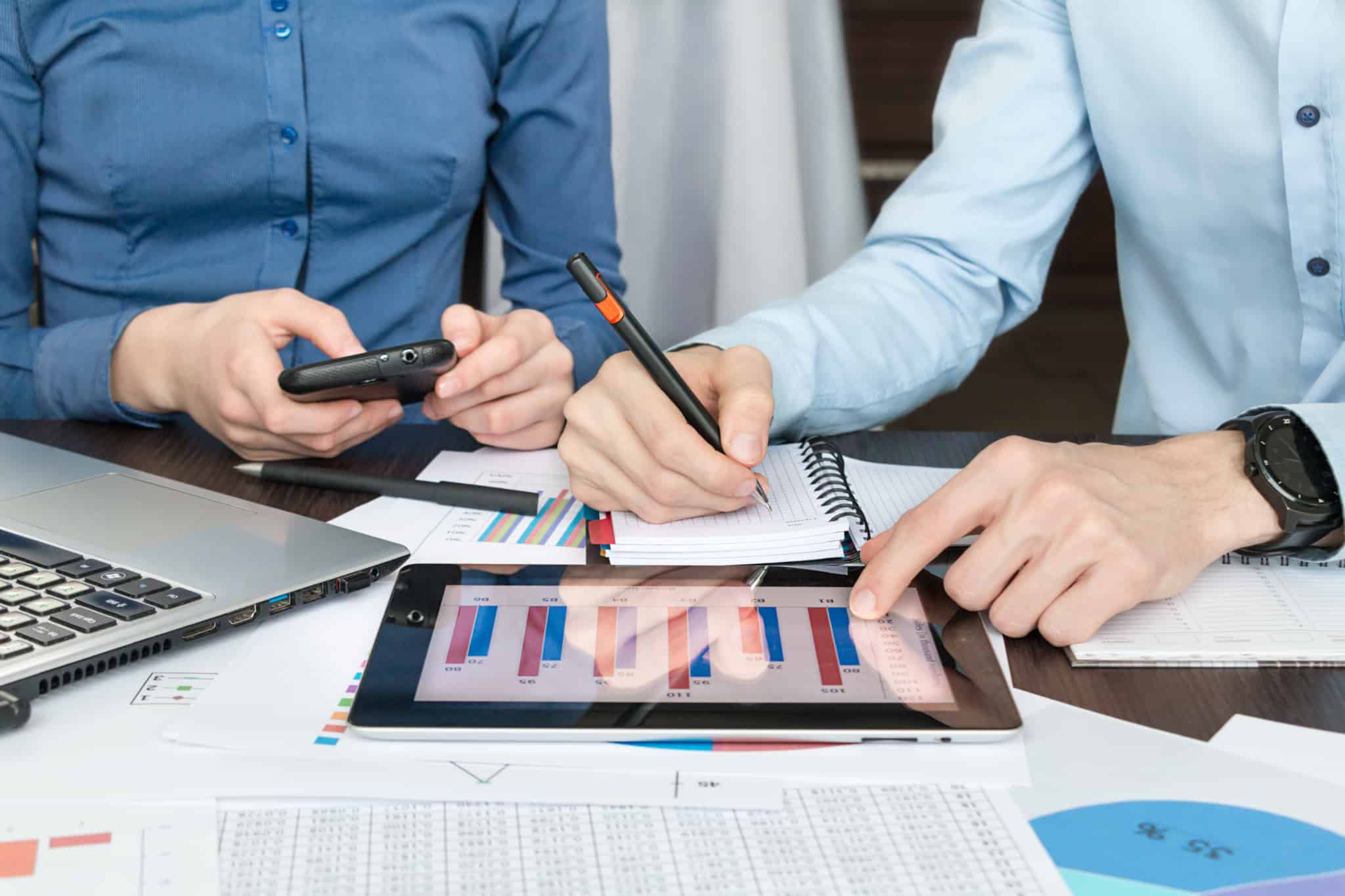 dois homens trabalham com um gráfico que aparece no tablet