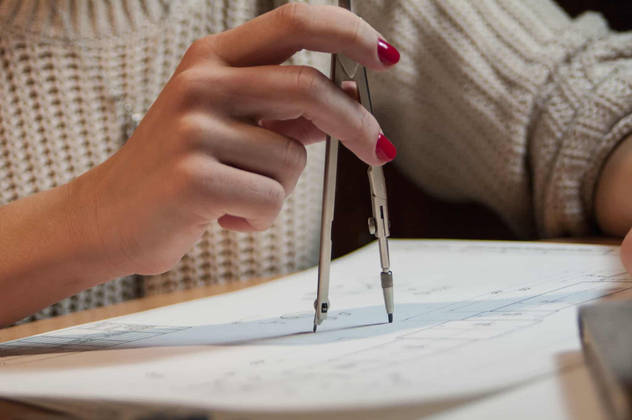 jovem desenha num papel com compasso