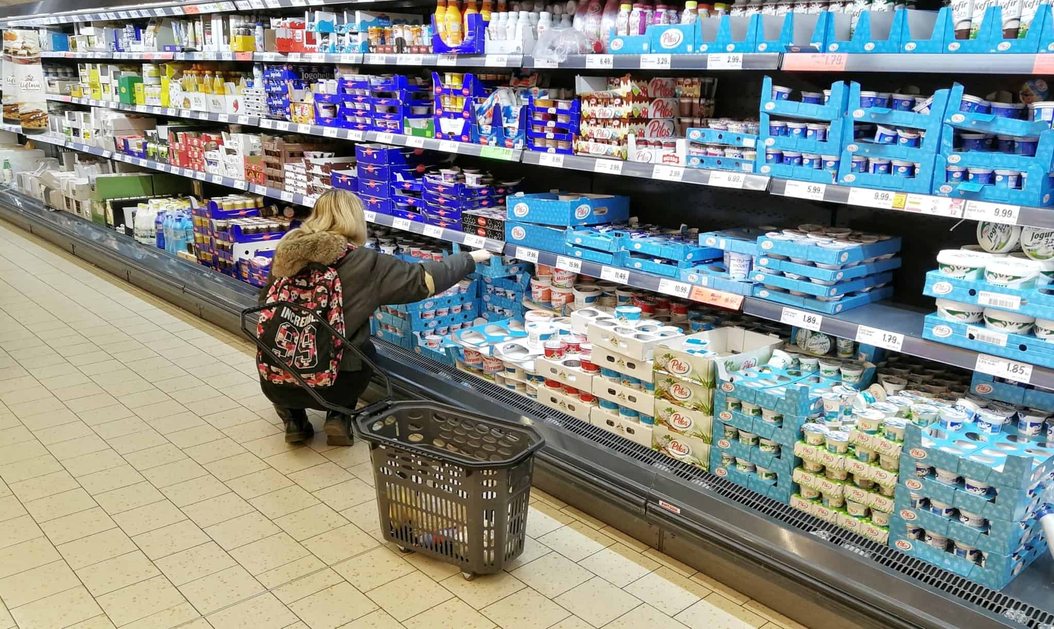 mulher a escolher iogurtes no supermercado