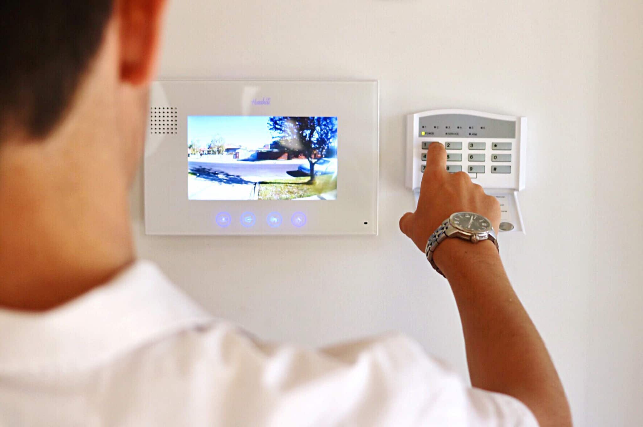 Homem a marcar código do alarme de casa