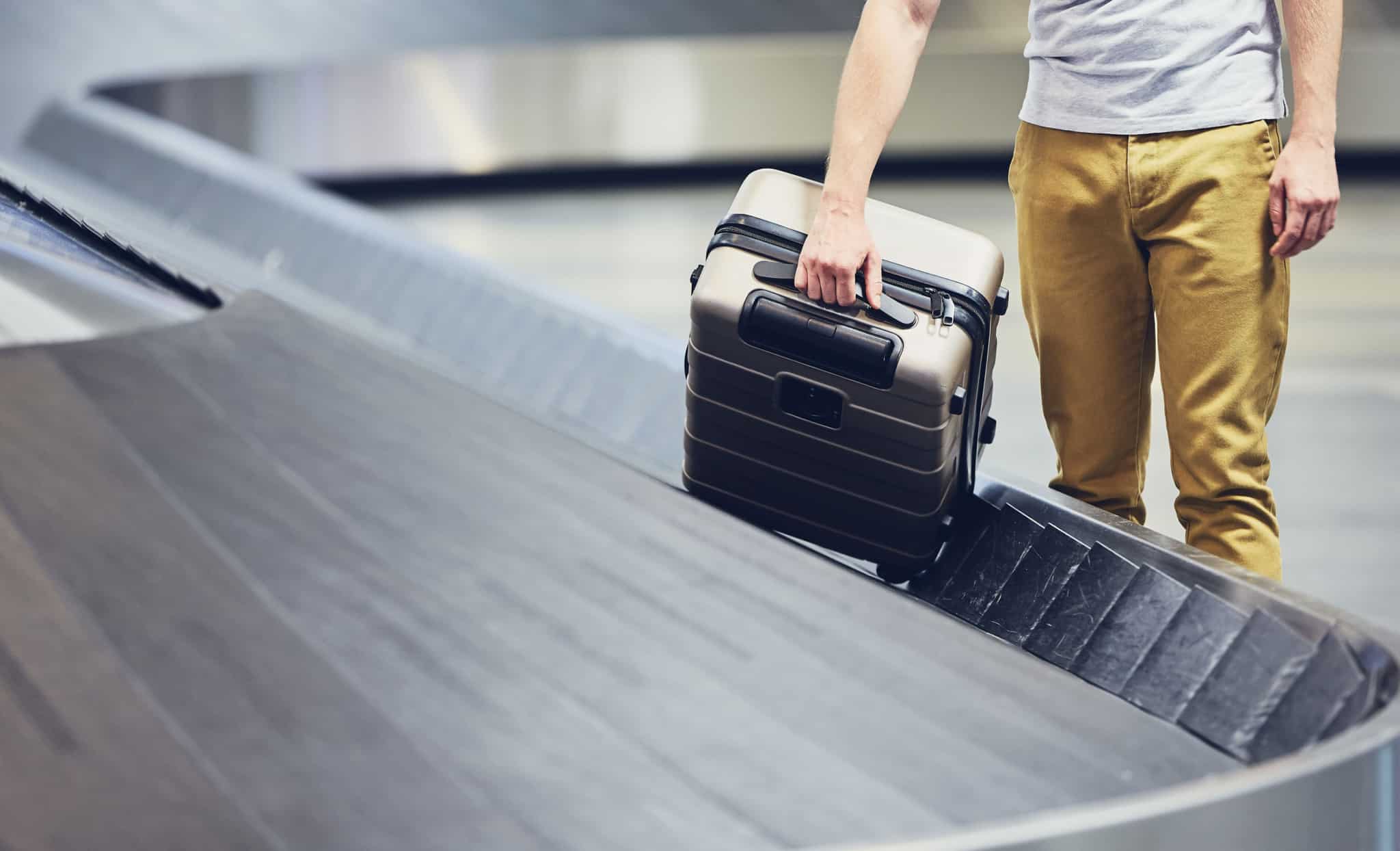 Homem-a-retirar-bagagem-da-passadeira-do-aeroporto