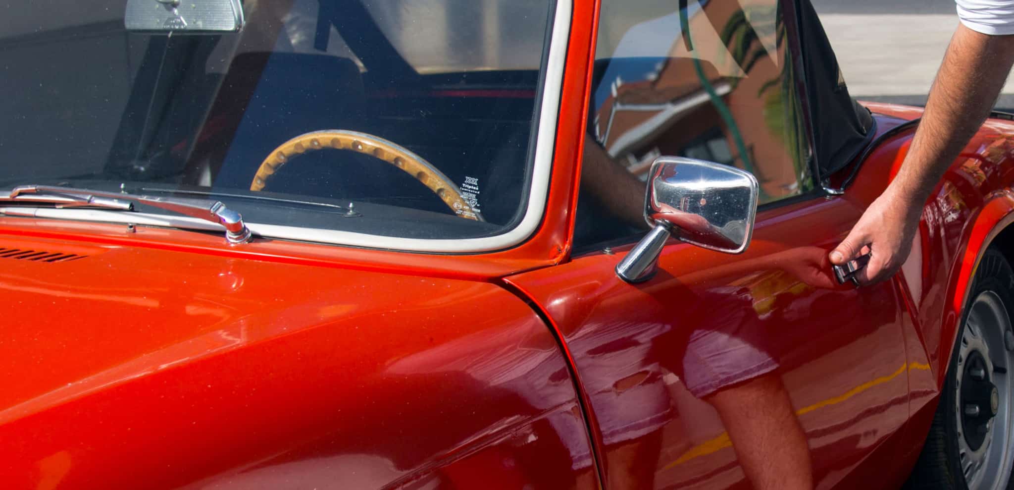 _homem a entrar em carro vermelho