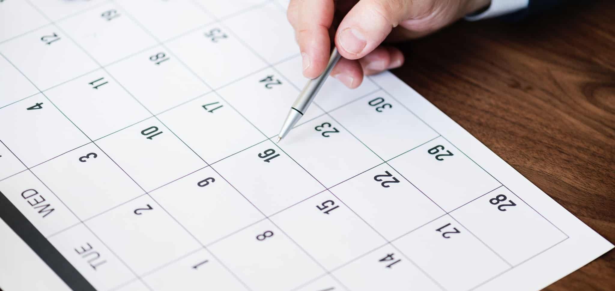 homem a fazer marcações no calendário comercial
