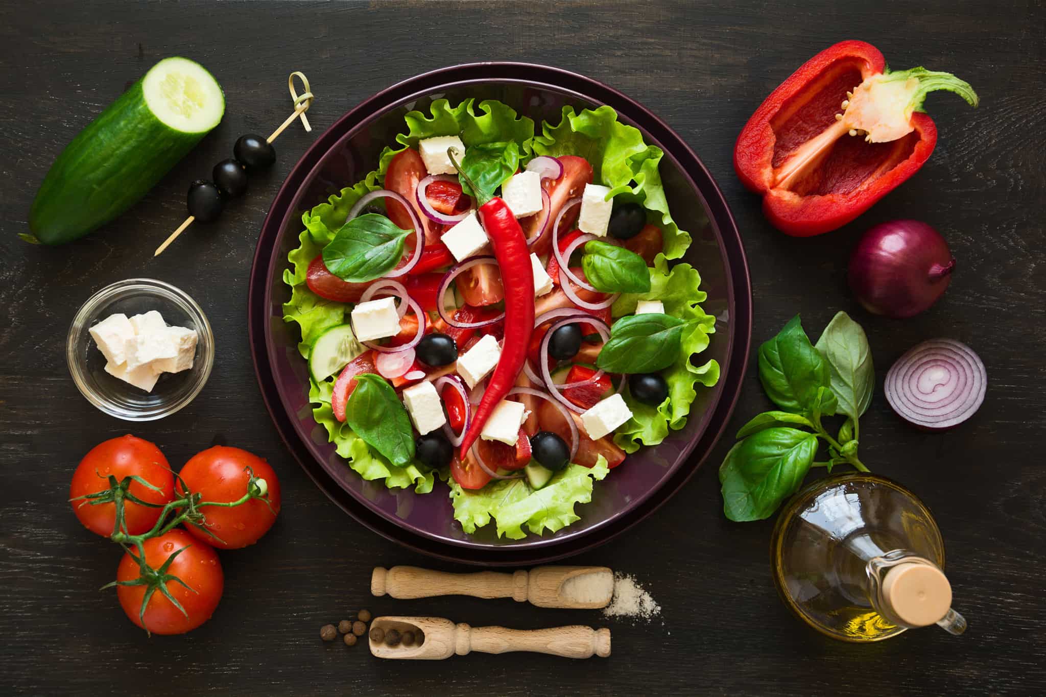 prato de salada e vegetais cortados em cima de uma mesa