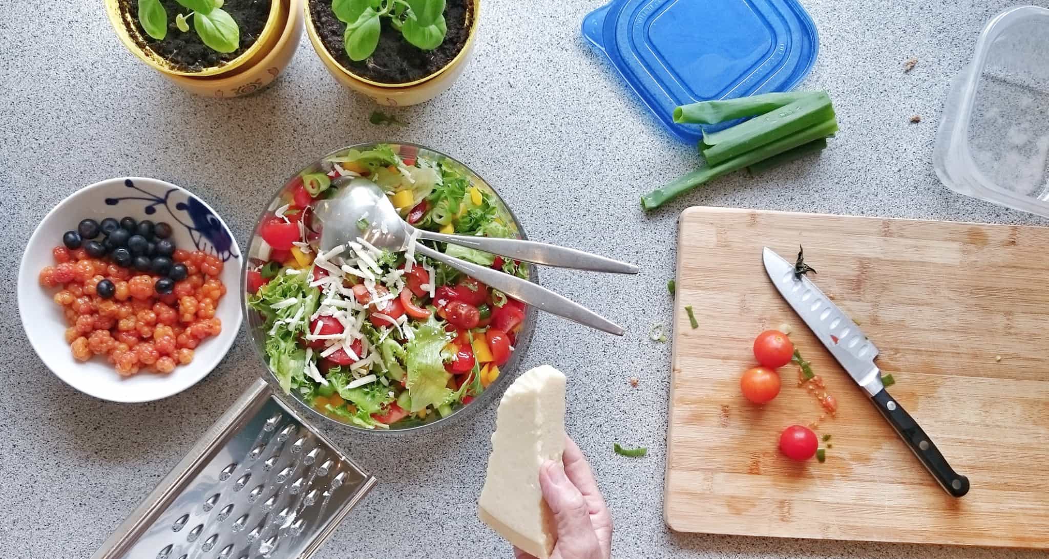 senhora a cozinhar vegetais numa bancada de cozinha
