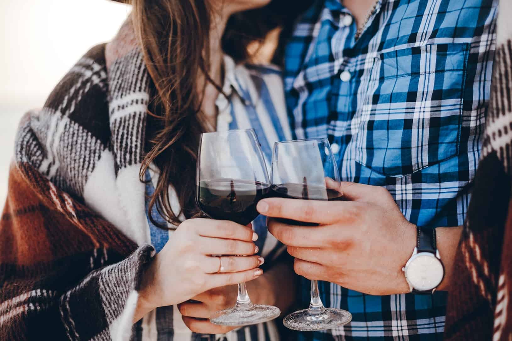 casal a fazer brinde com copo de vinho