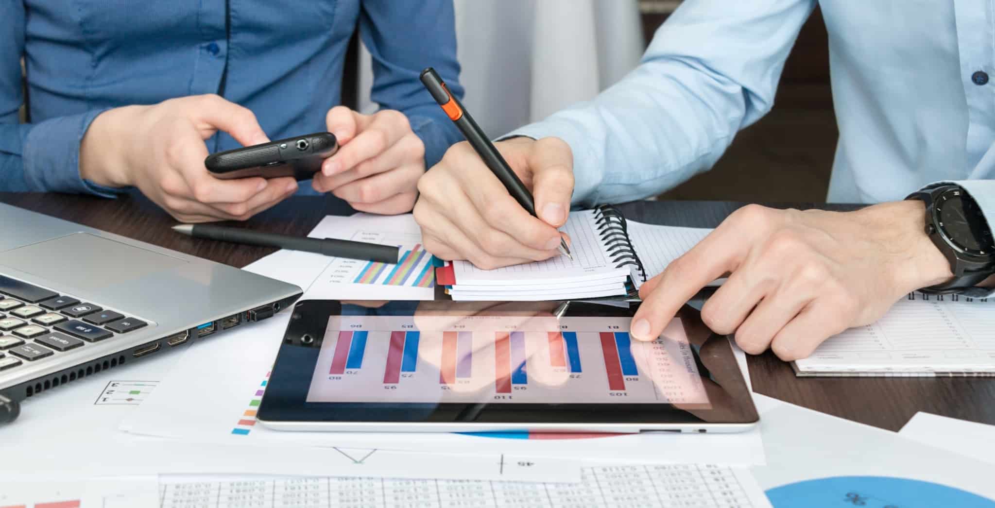 Dois empresários a verificar aplicações financeiras e a fazer contas