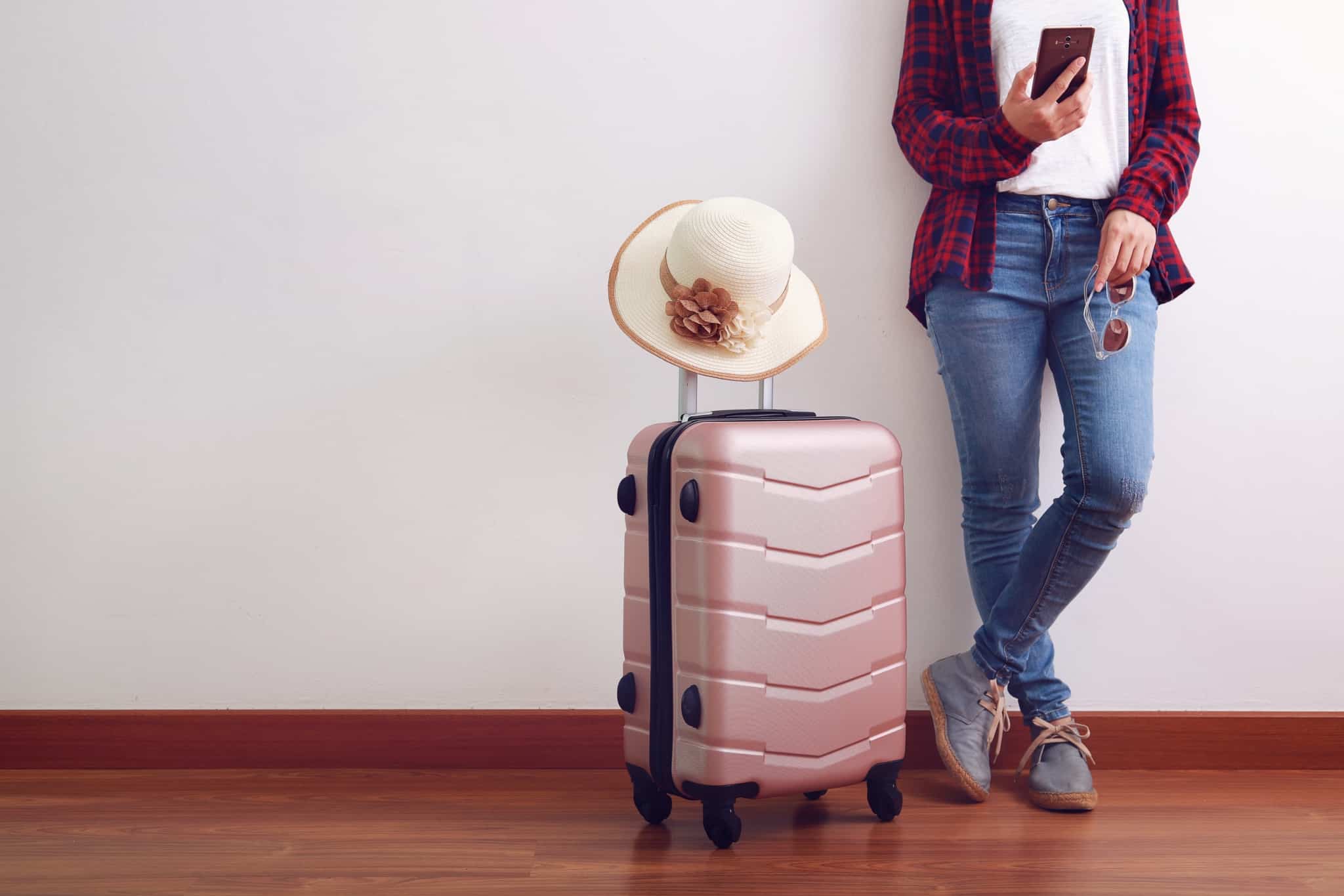 rapariga pronta para viajar com trolley de viagem
