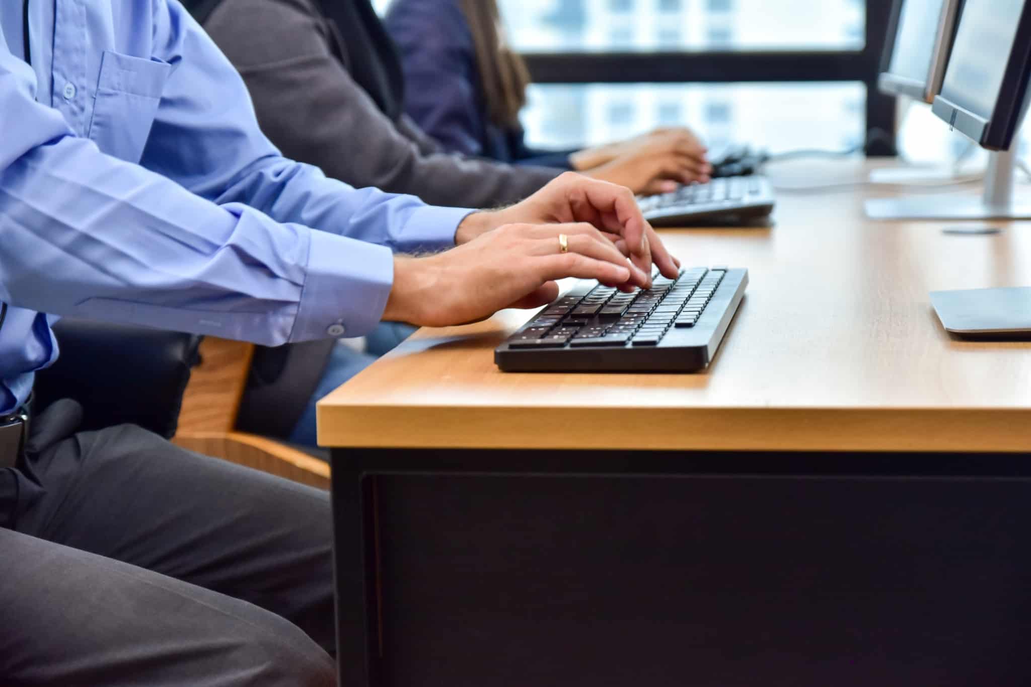 pessoas num balcão a escrever no teclado