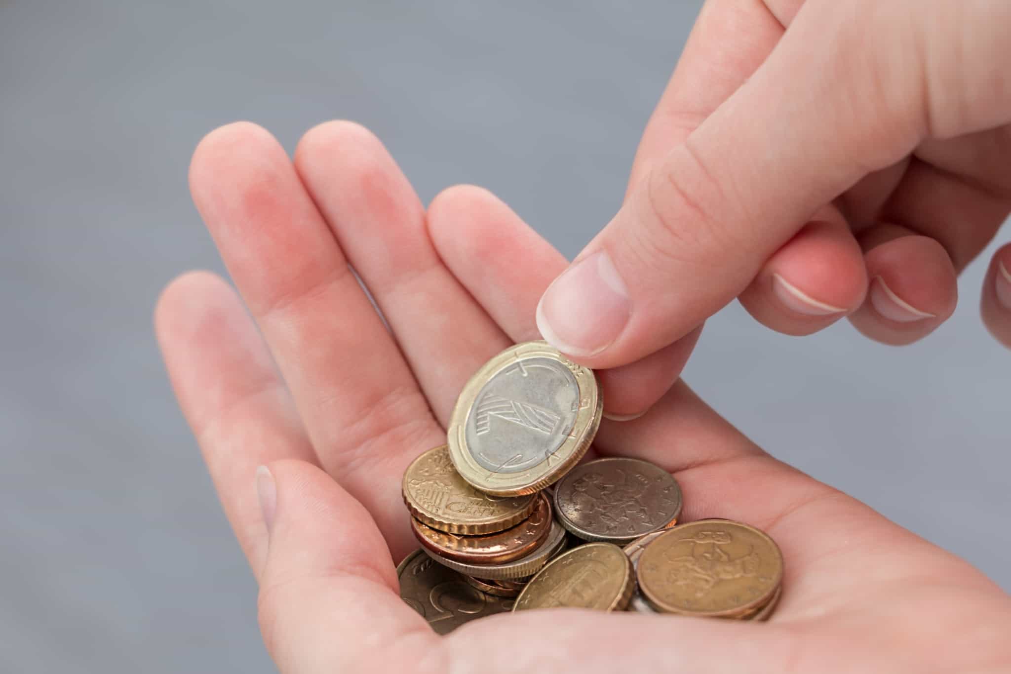 moedas de euros na mão de uma pessoa