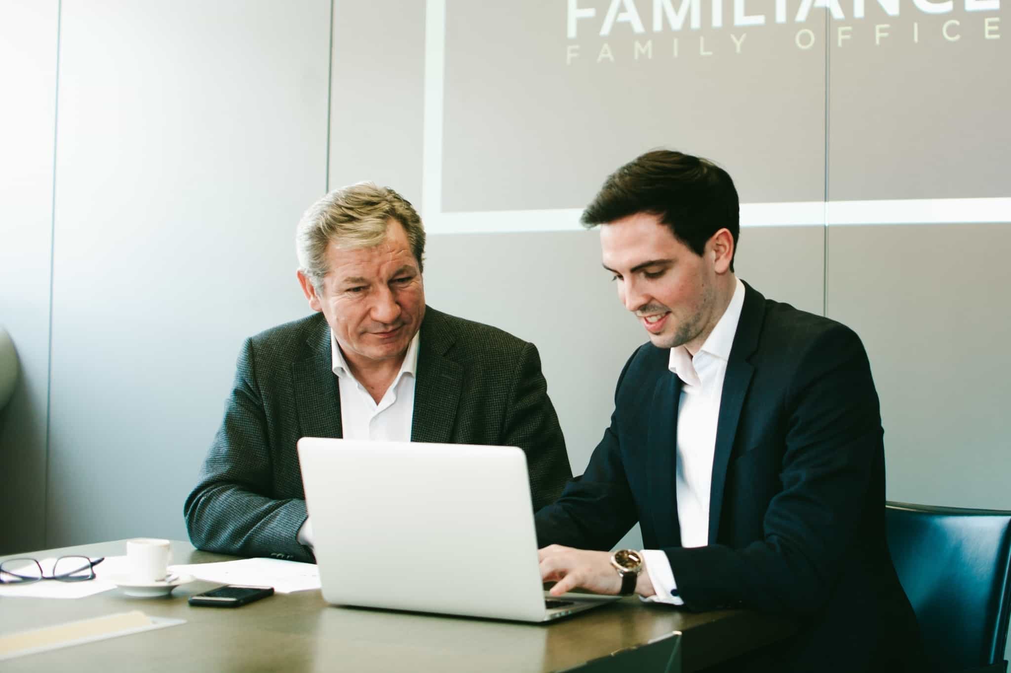 dois empresários com um portátil à frente