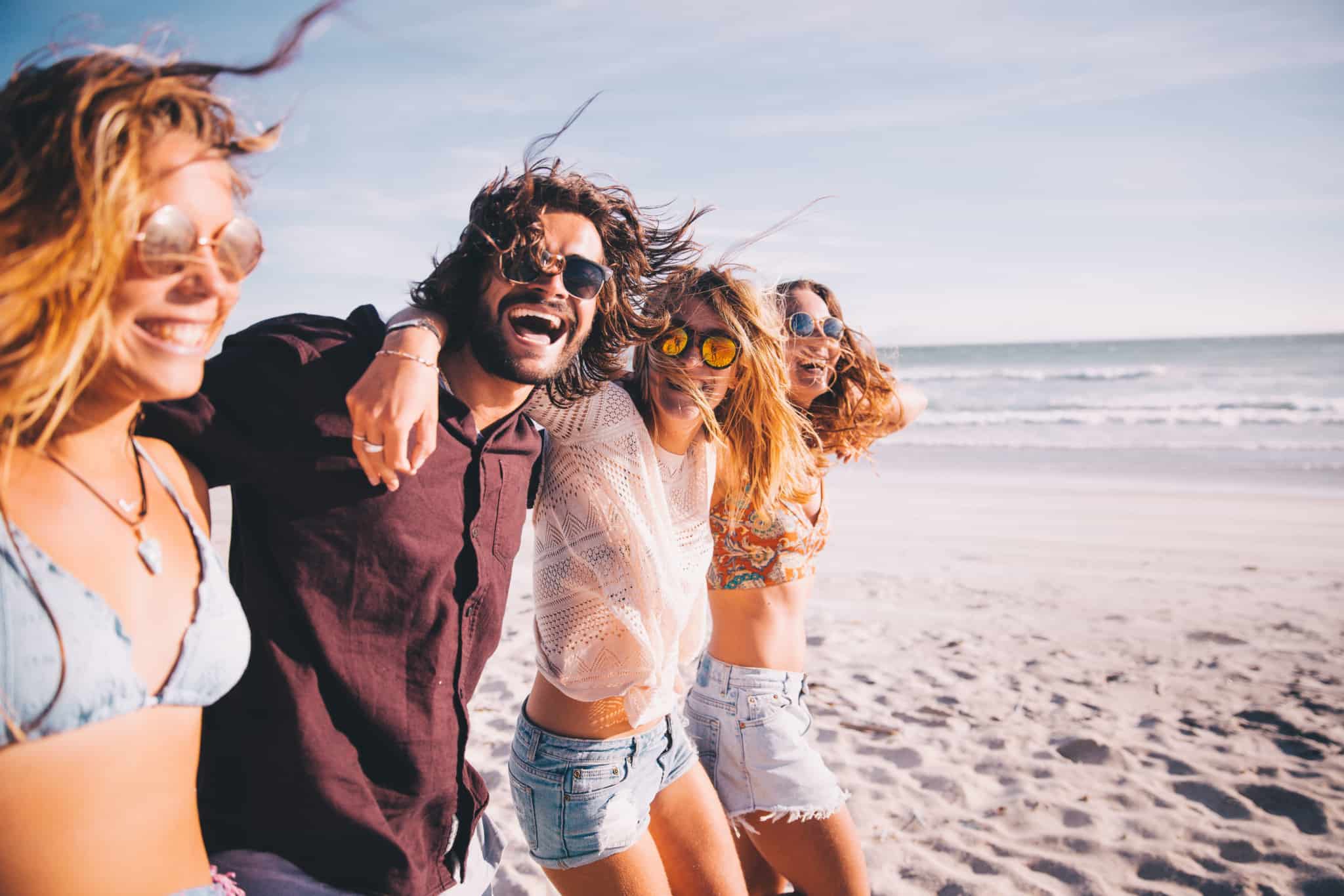 grupo de amigos na praia sorridentes