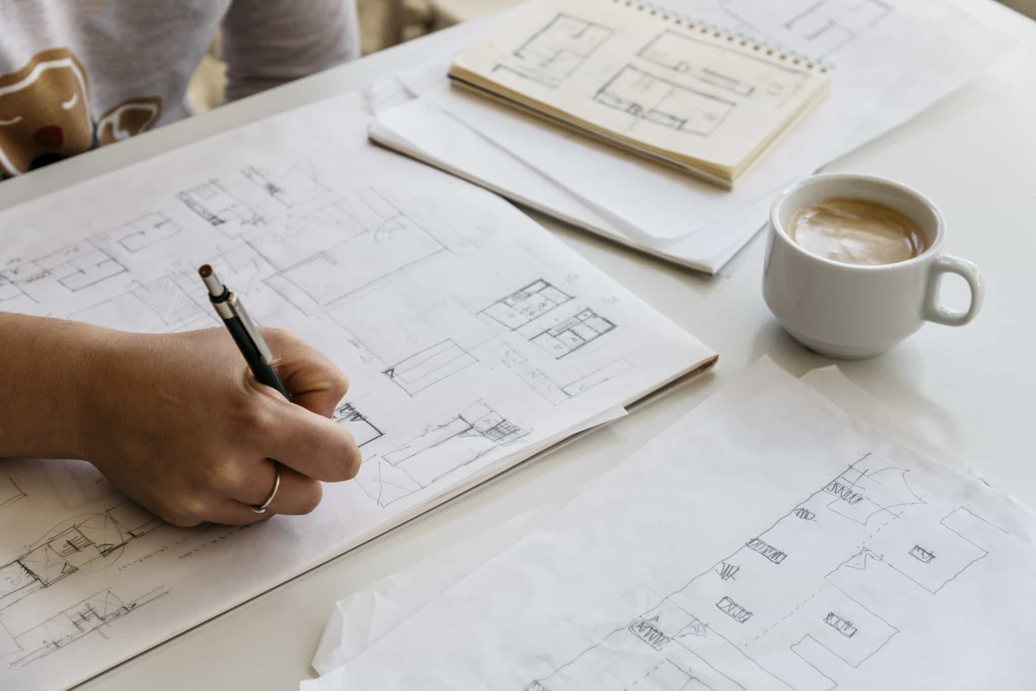 arquitecta a fazer projeto com chavena de cafe