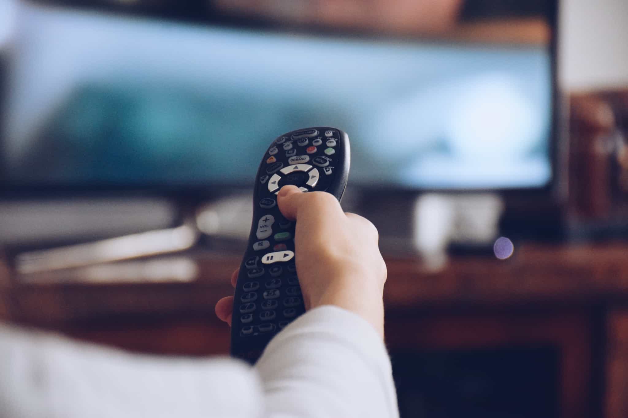 pessoa mexe no comando da televisão