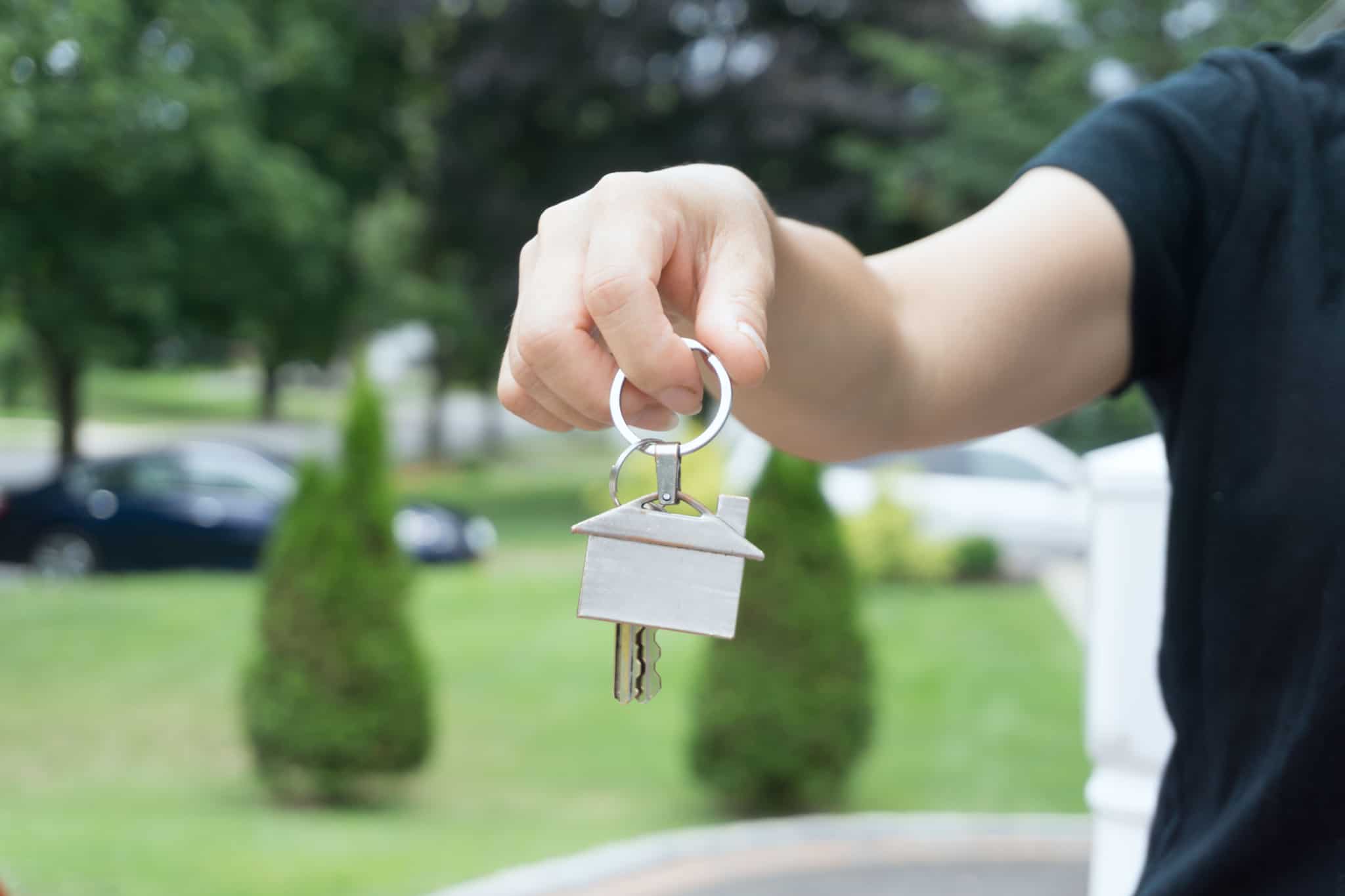 Homem a segurar em porta chaves de uma casa