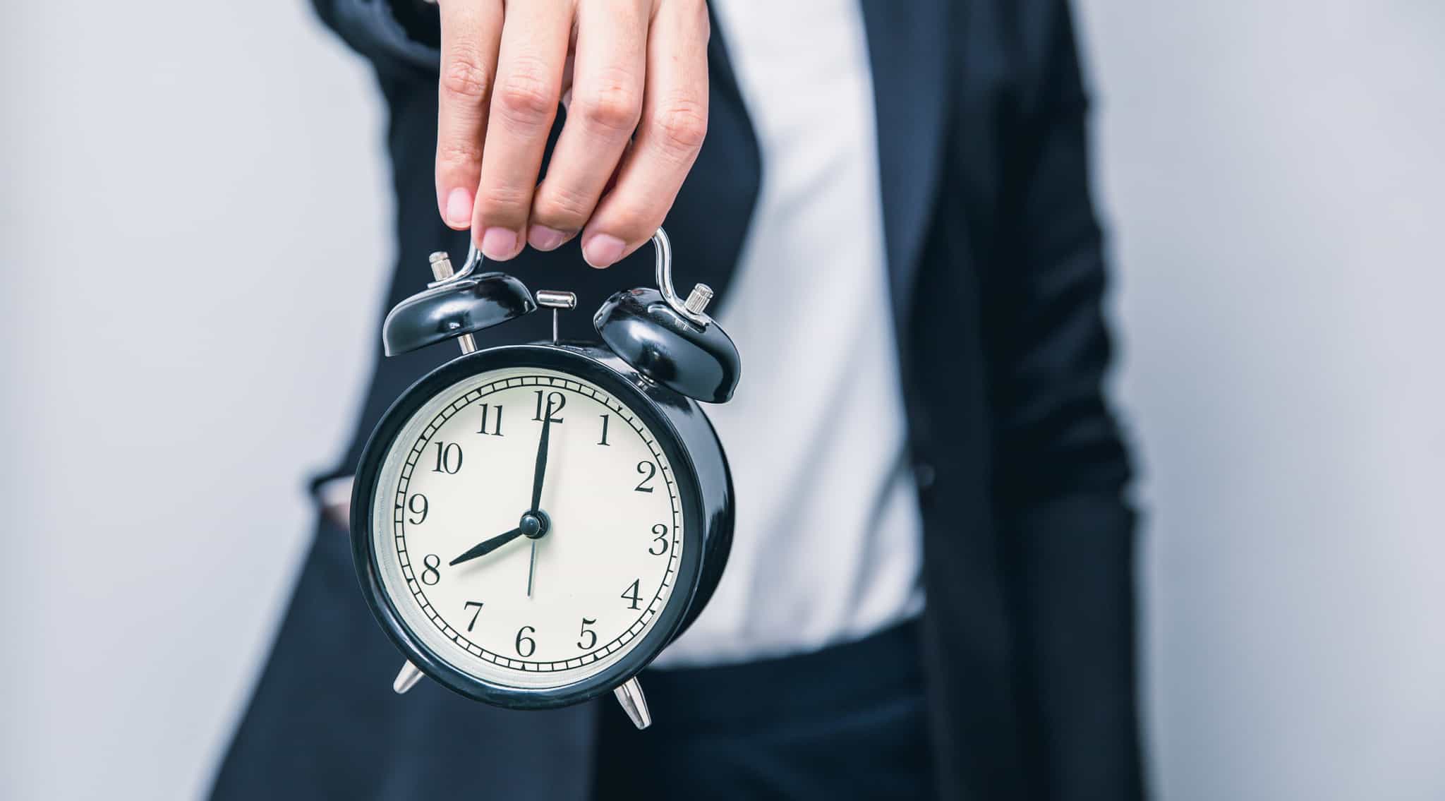 Homem-a-segurar-num-relogio-depertador_horario-flexivel