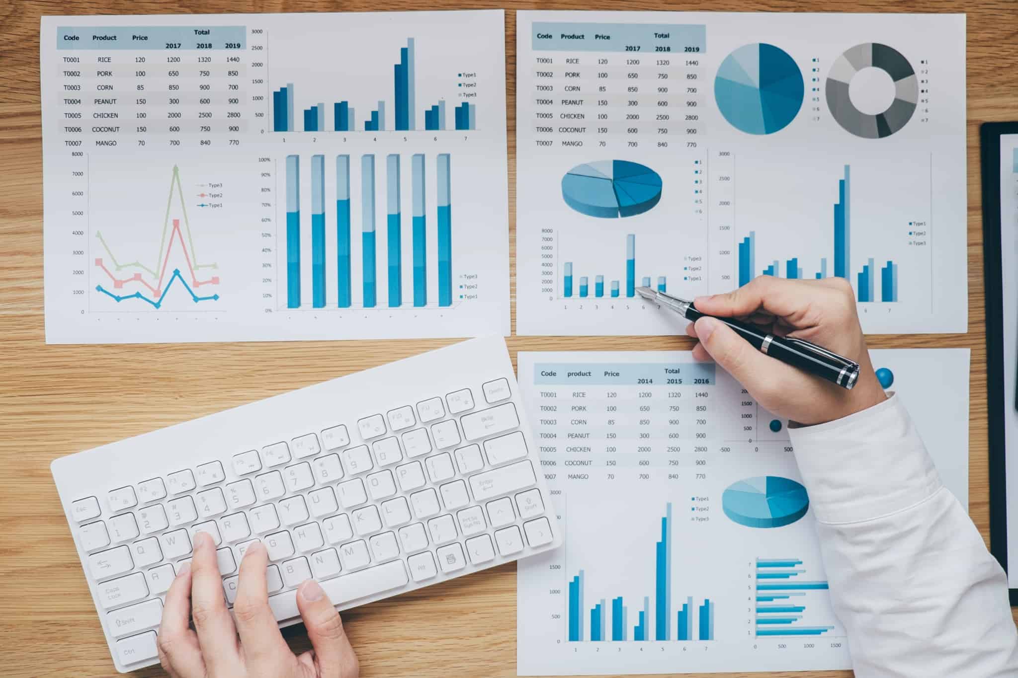 profissional a analisar várias folhas com gráficos azuis