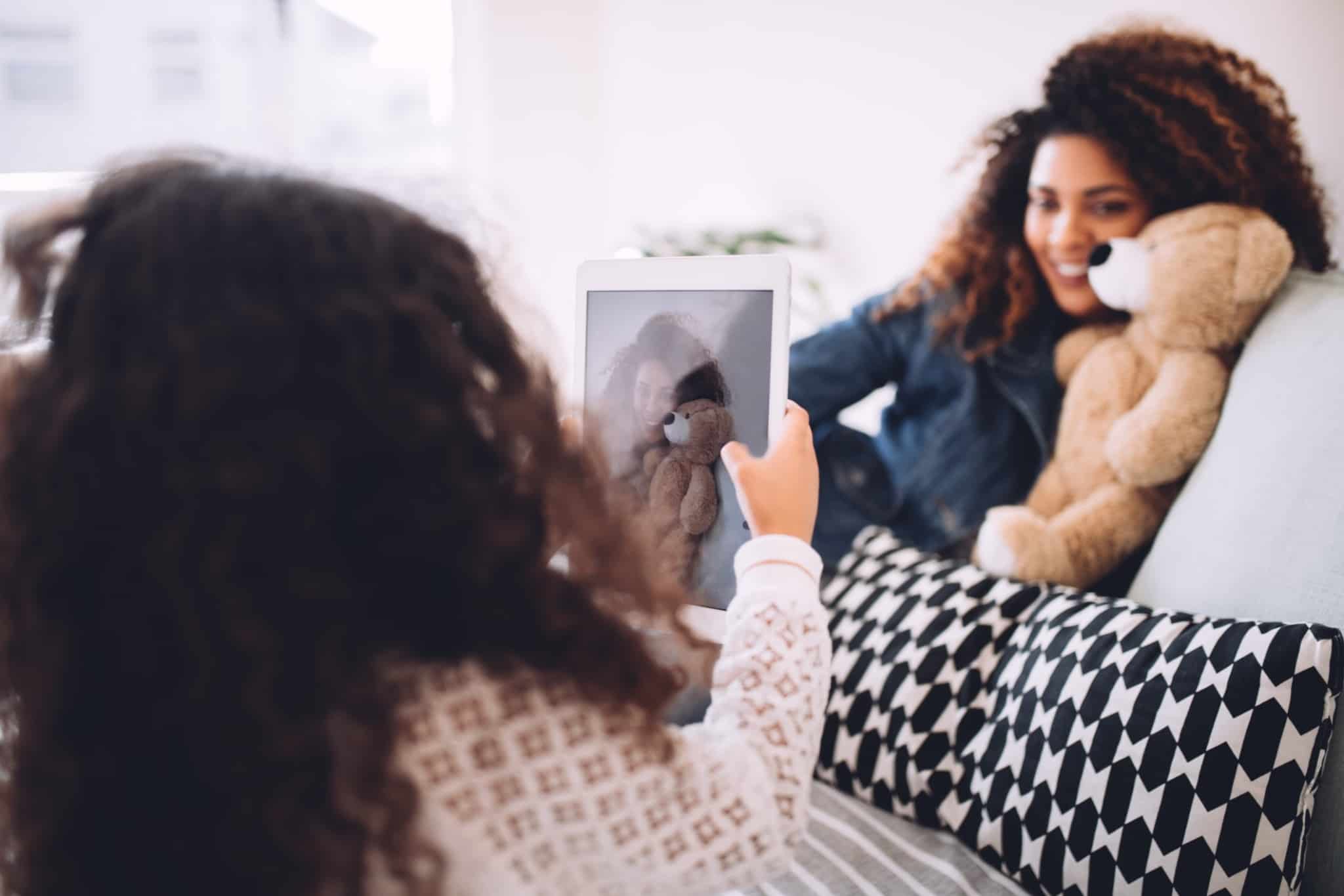 filha a tirar foto à mãe através de um tablet