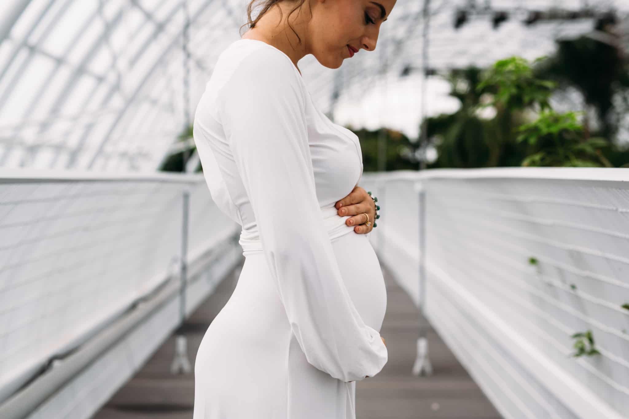 grávida vestida com vestido branco de mangas