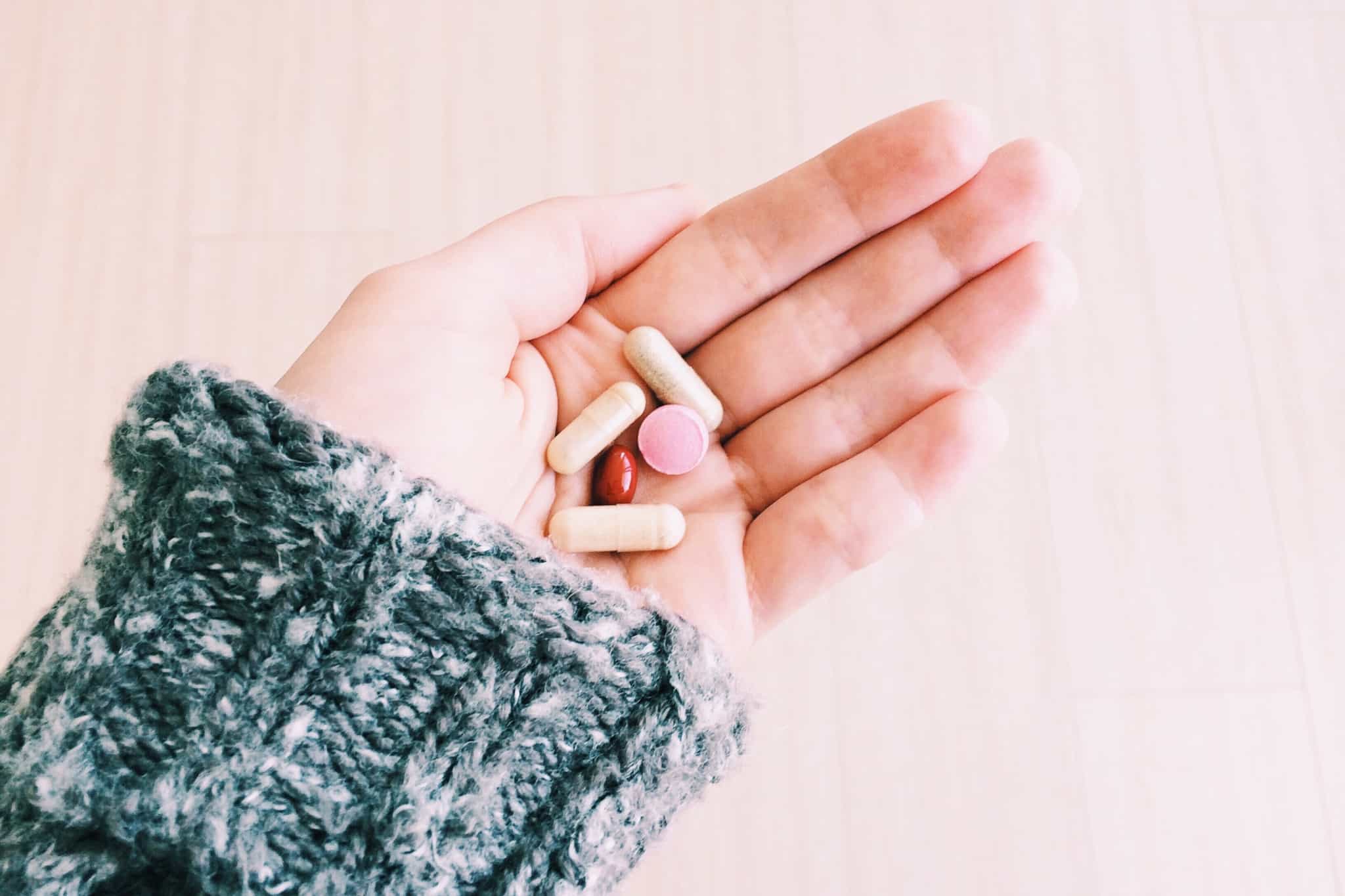 rapariga com medicamentos na mão