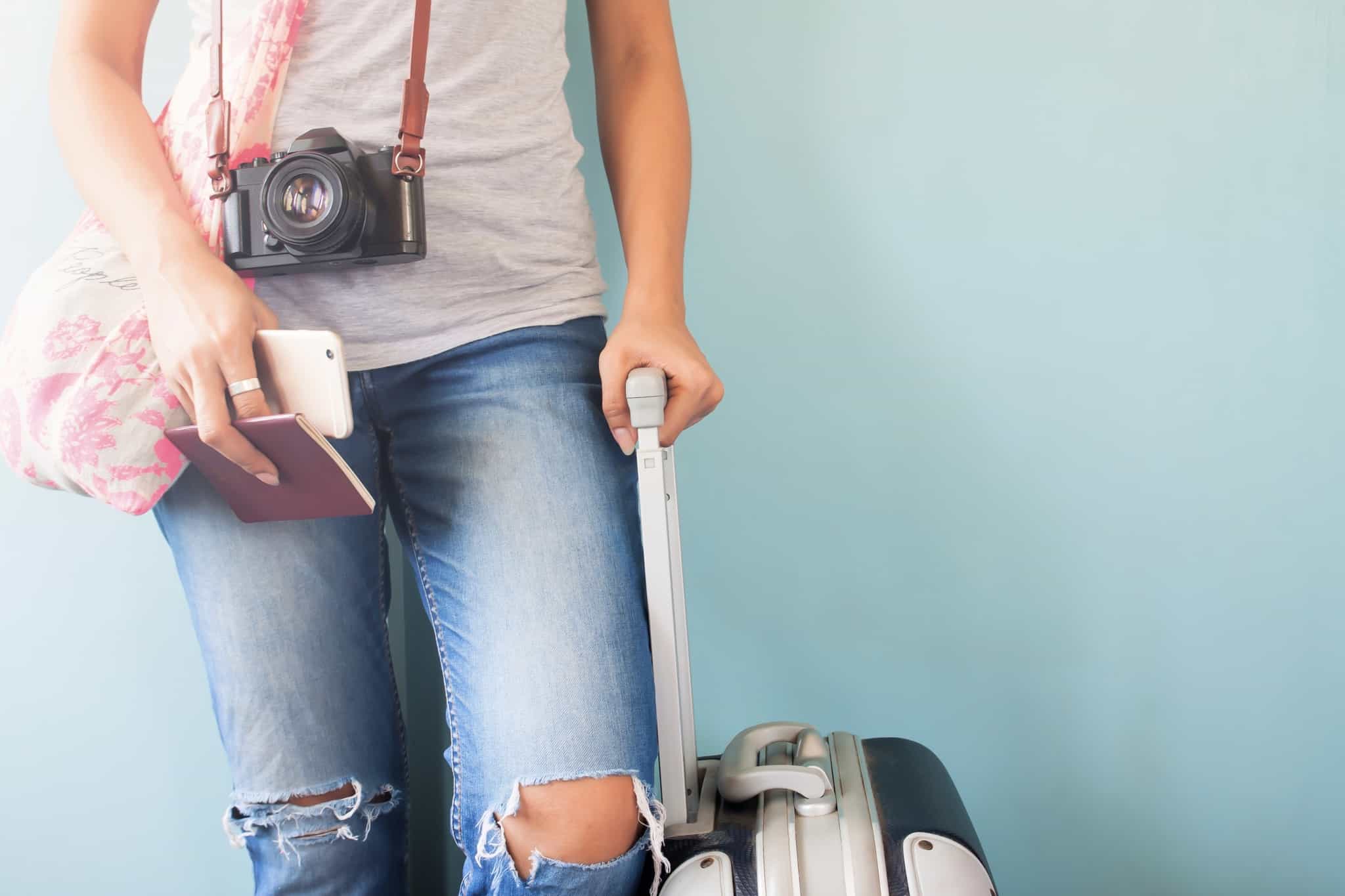 mulher pronta para viajar com trolley e passaporte na mão
