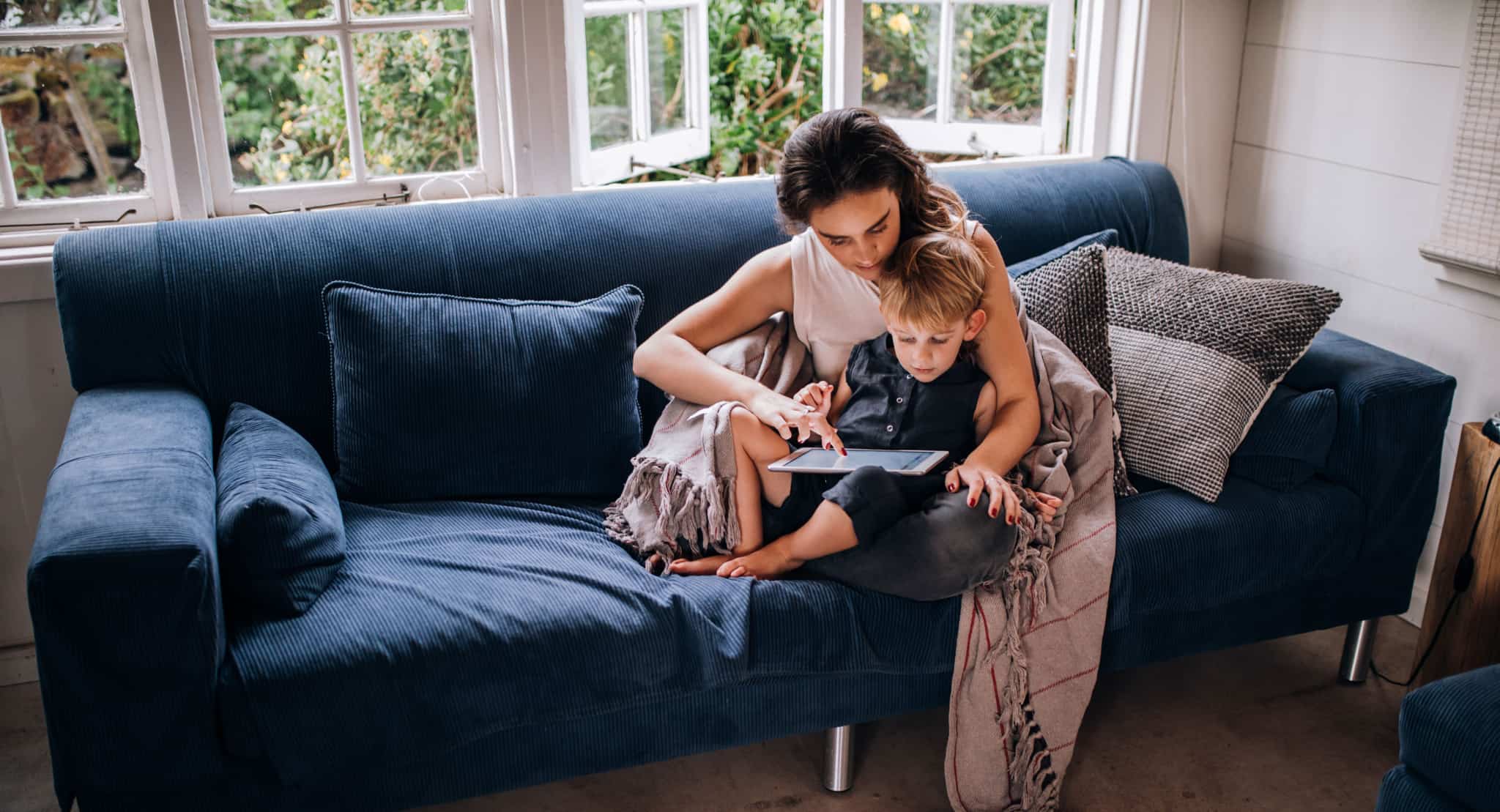 mãe com filho ao colo sentados no sofá