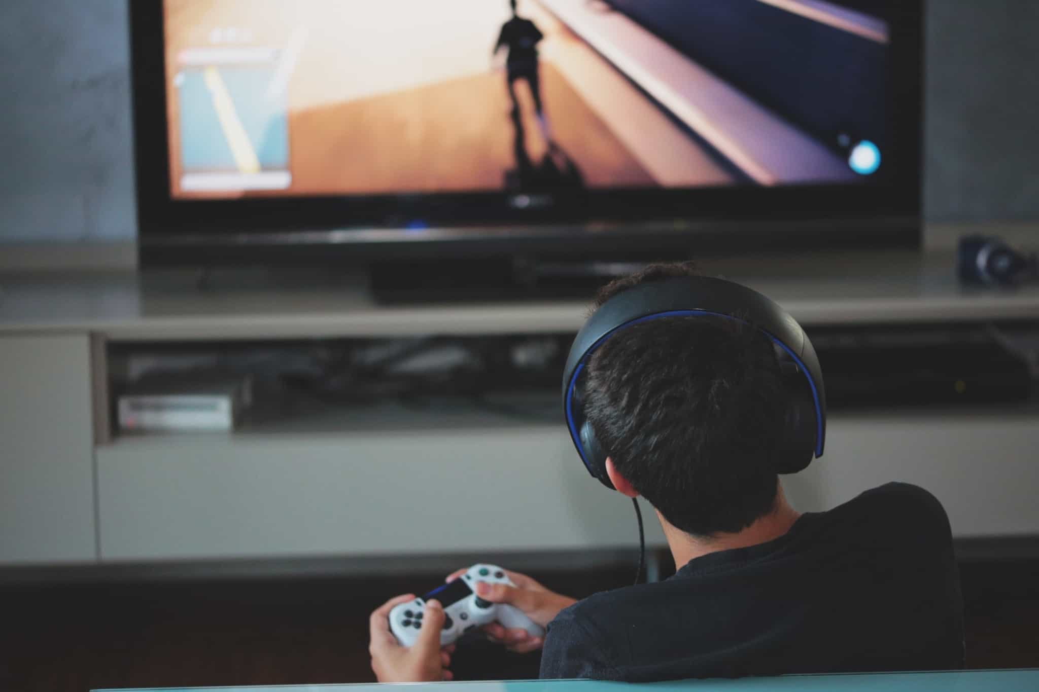 rapaz a jogar consola na televisão