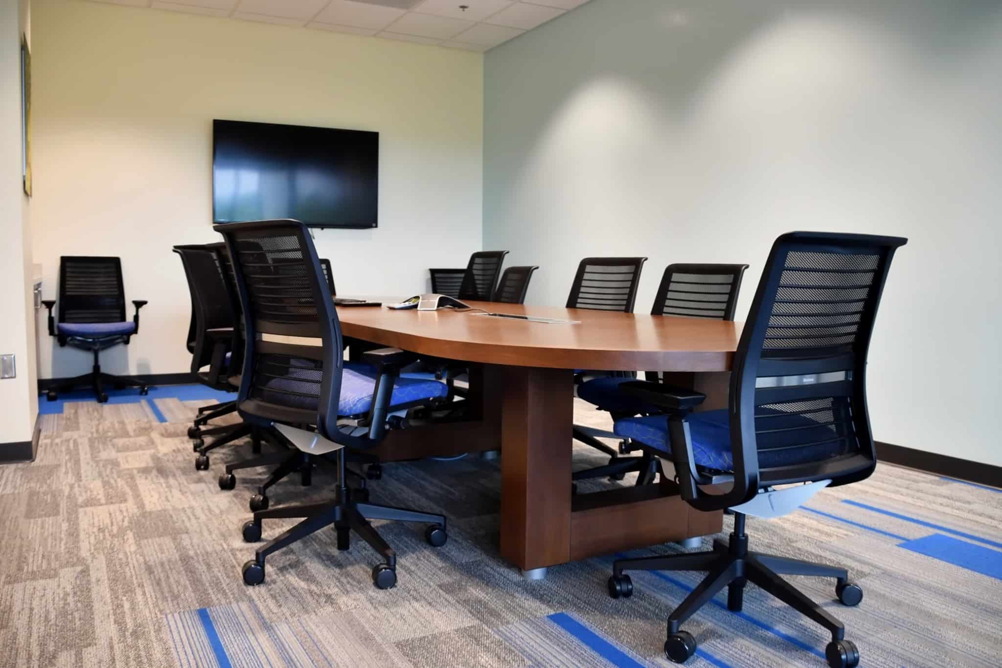 sala de reuniões com cadeiras pretas à volta da mesa