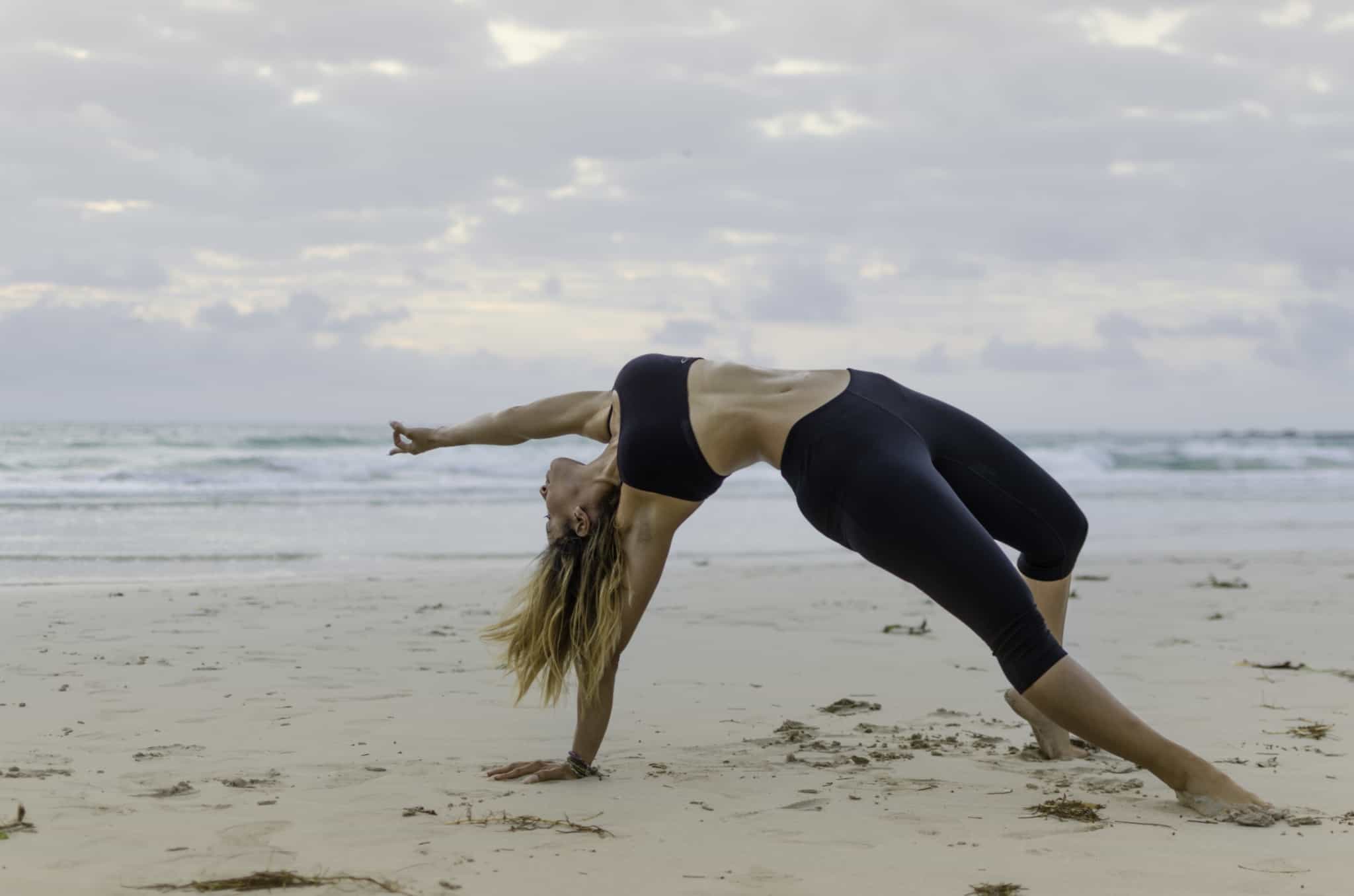 rapariga em posiçãod e yoga na praia