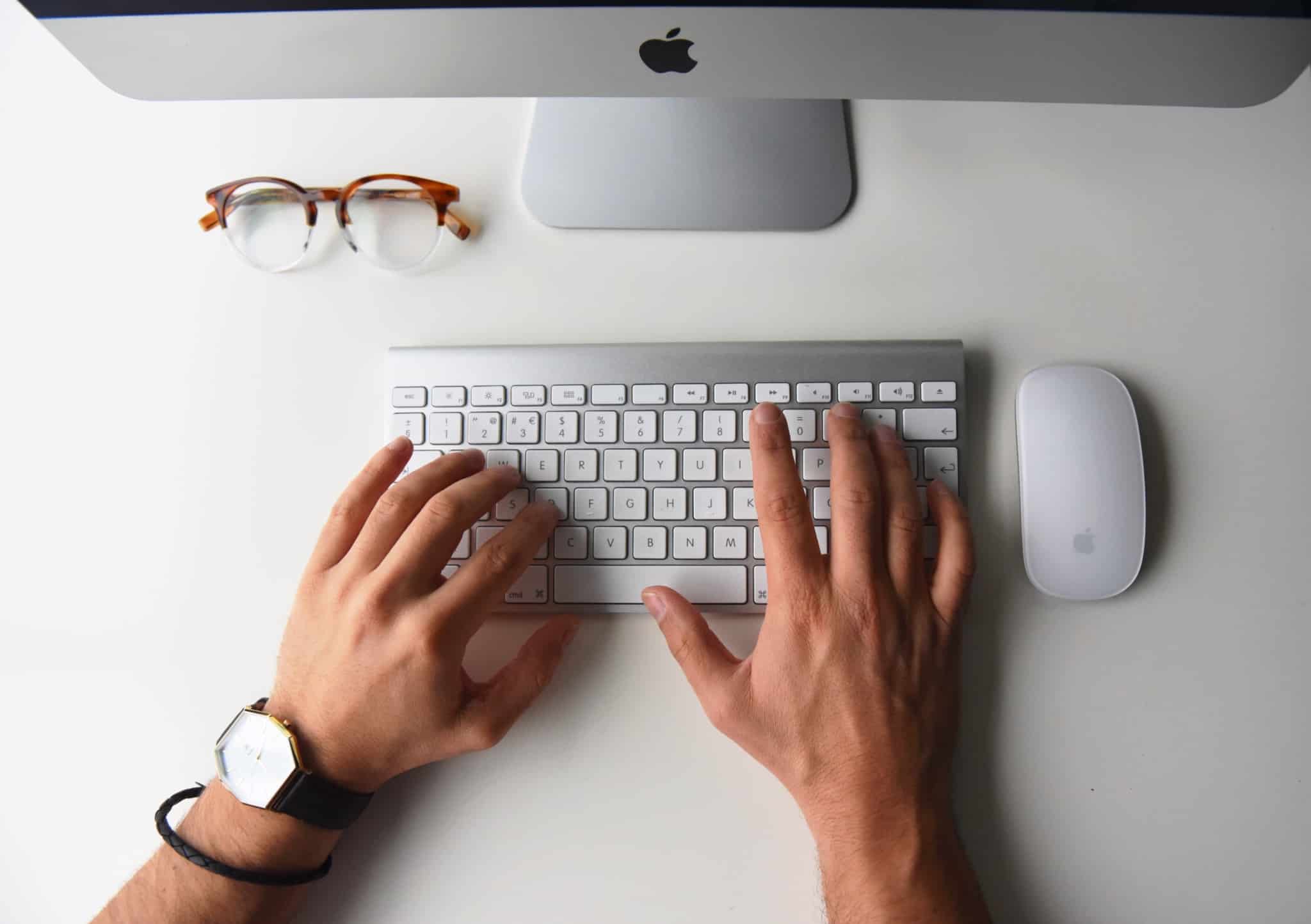 pessoa a escrever no teclado de um mac