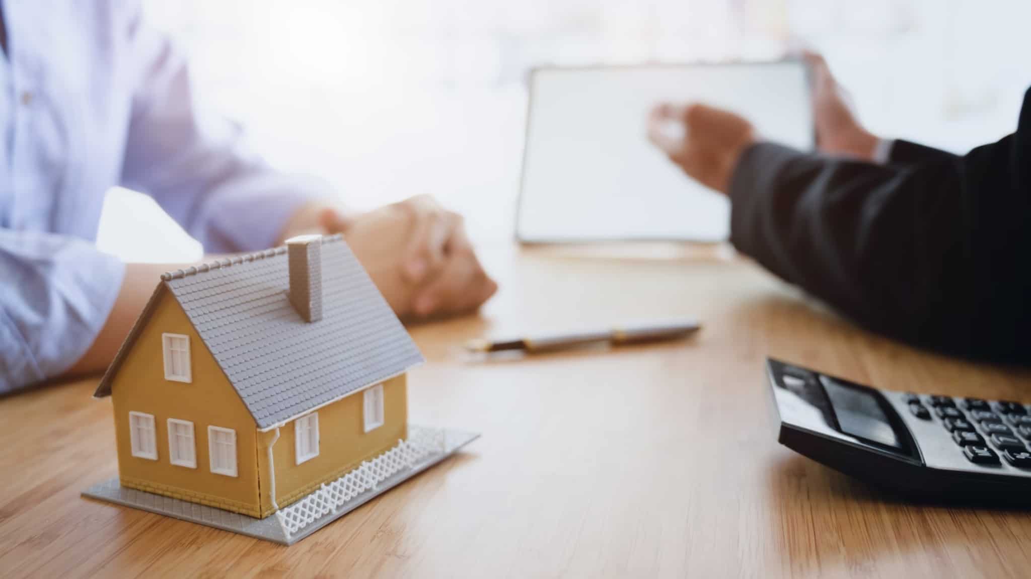 duas pessoas reunidas com uma calculadora em cima da mesa - mais-valias - herança