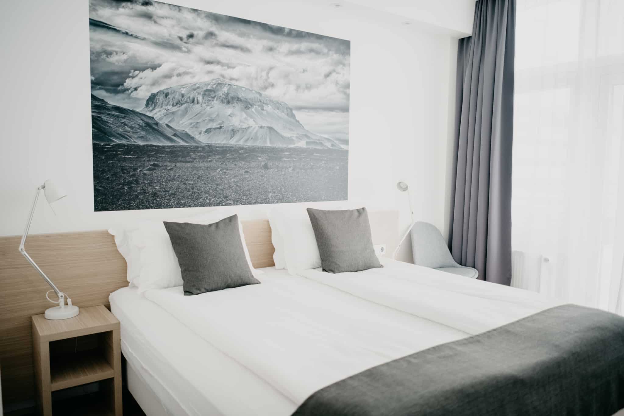 quarto de hotel com duas camas um quadro com um iceberg na parede
