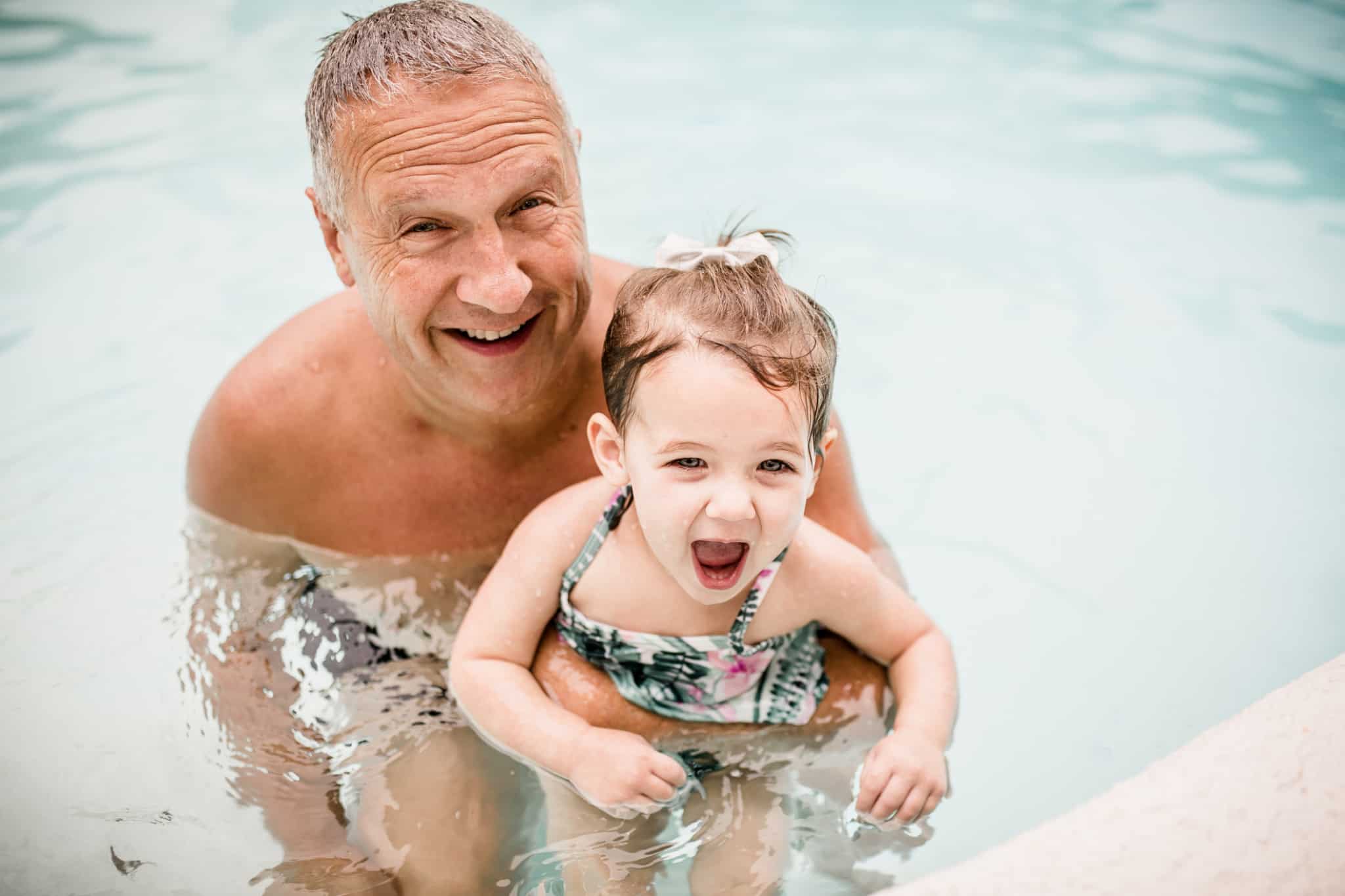 avô a nadar com a neta na piscina