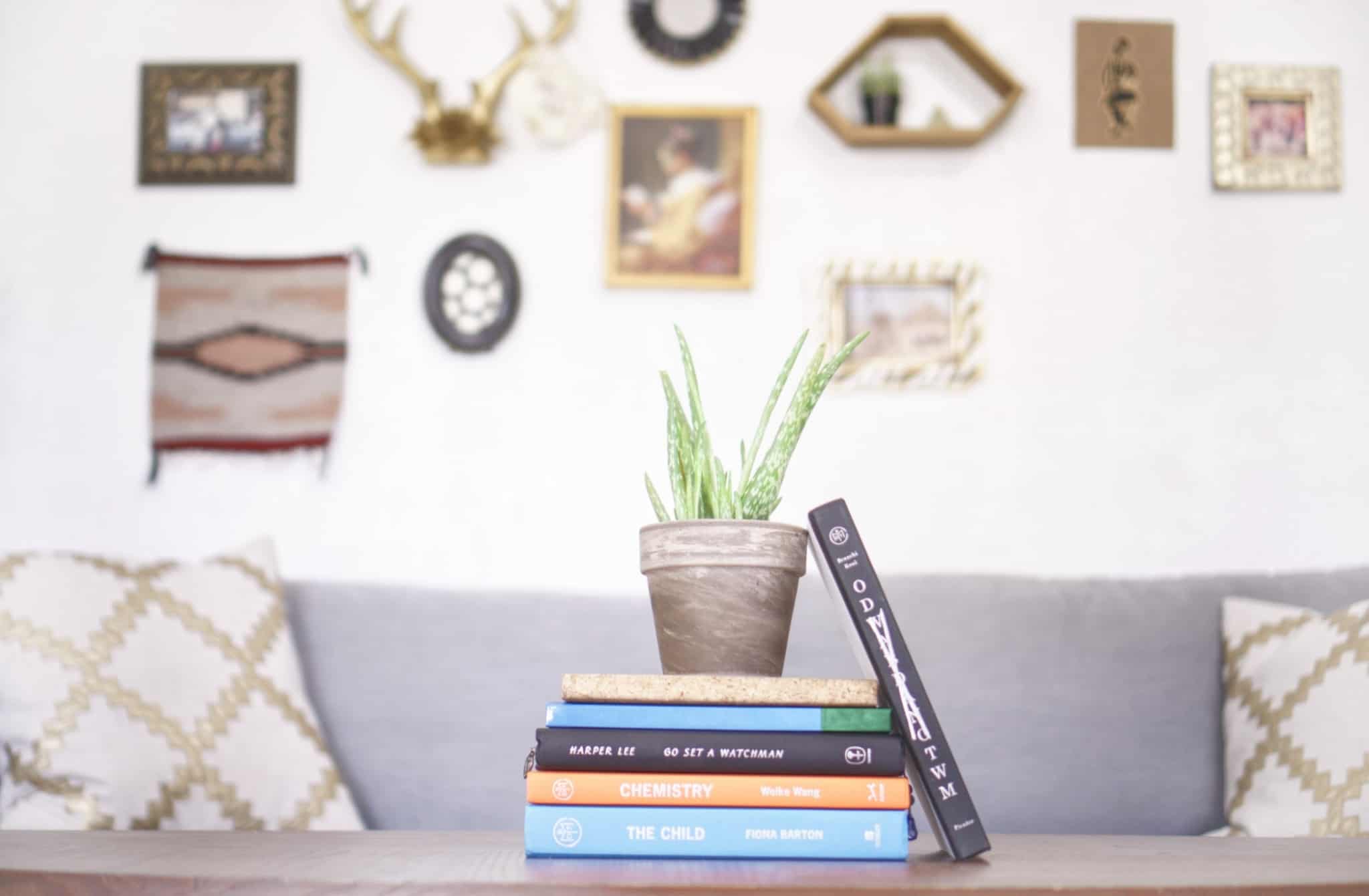 mesa central com livros e uma parede com vários quadros