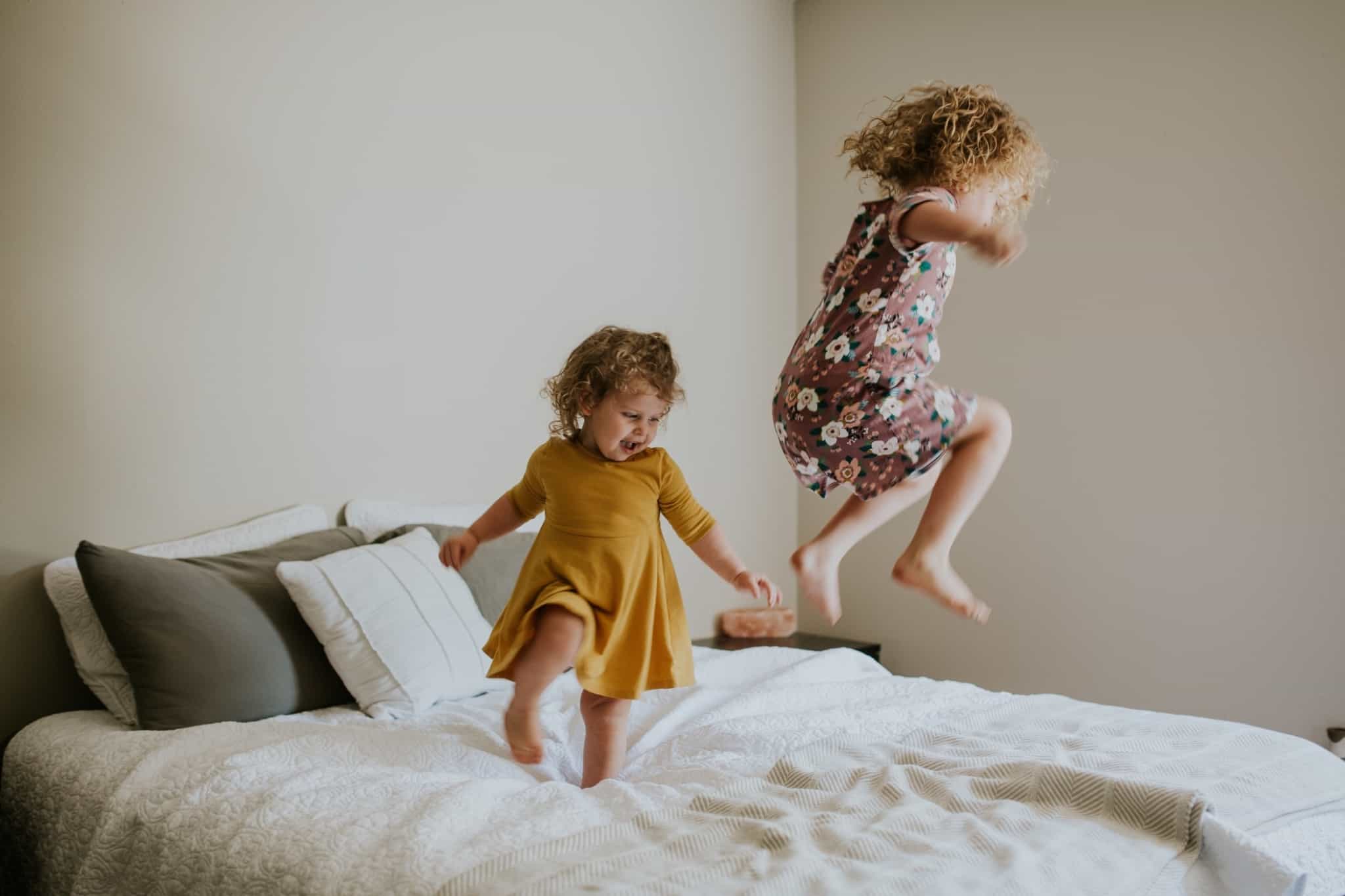 duas meninas a saltar em cima da cama