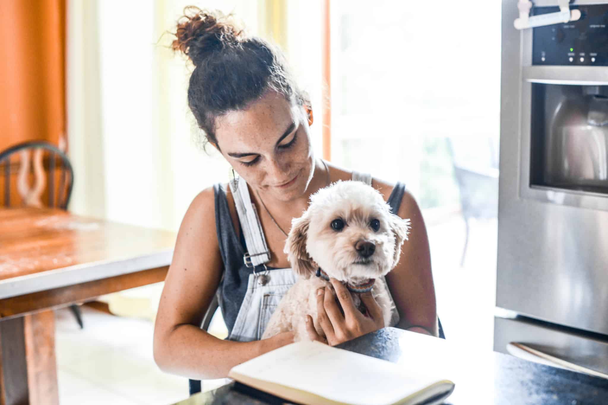 rapariga a segurar o cão ao colo